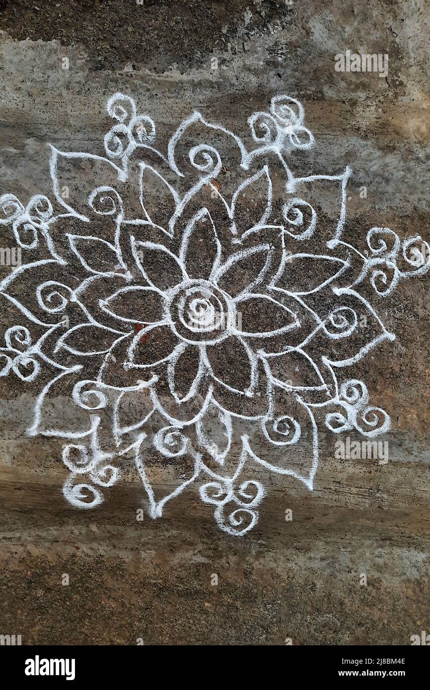 View of flower design in rangoli folk art drawn with white stone powder Stock Photo