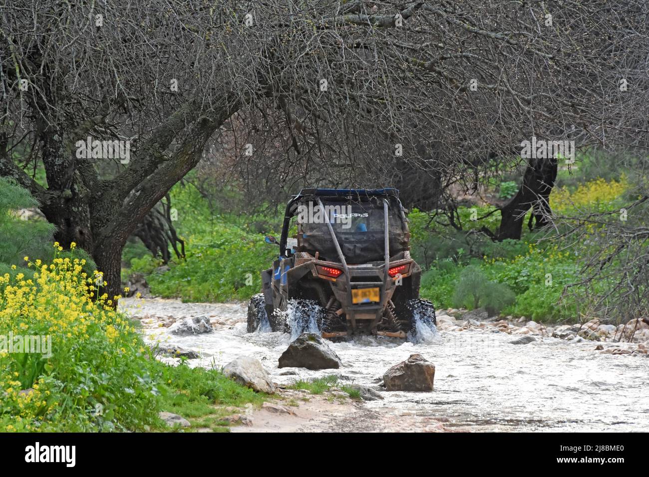 ATV  crossing a stream in winter,Galilee, Israel Stock Photo