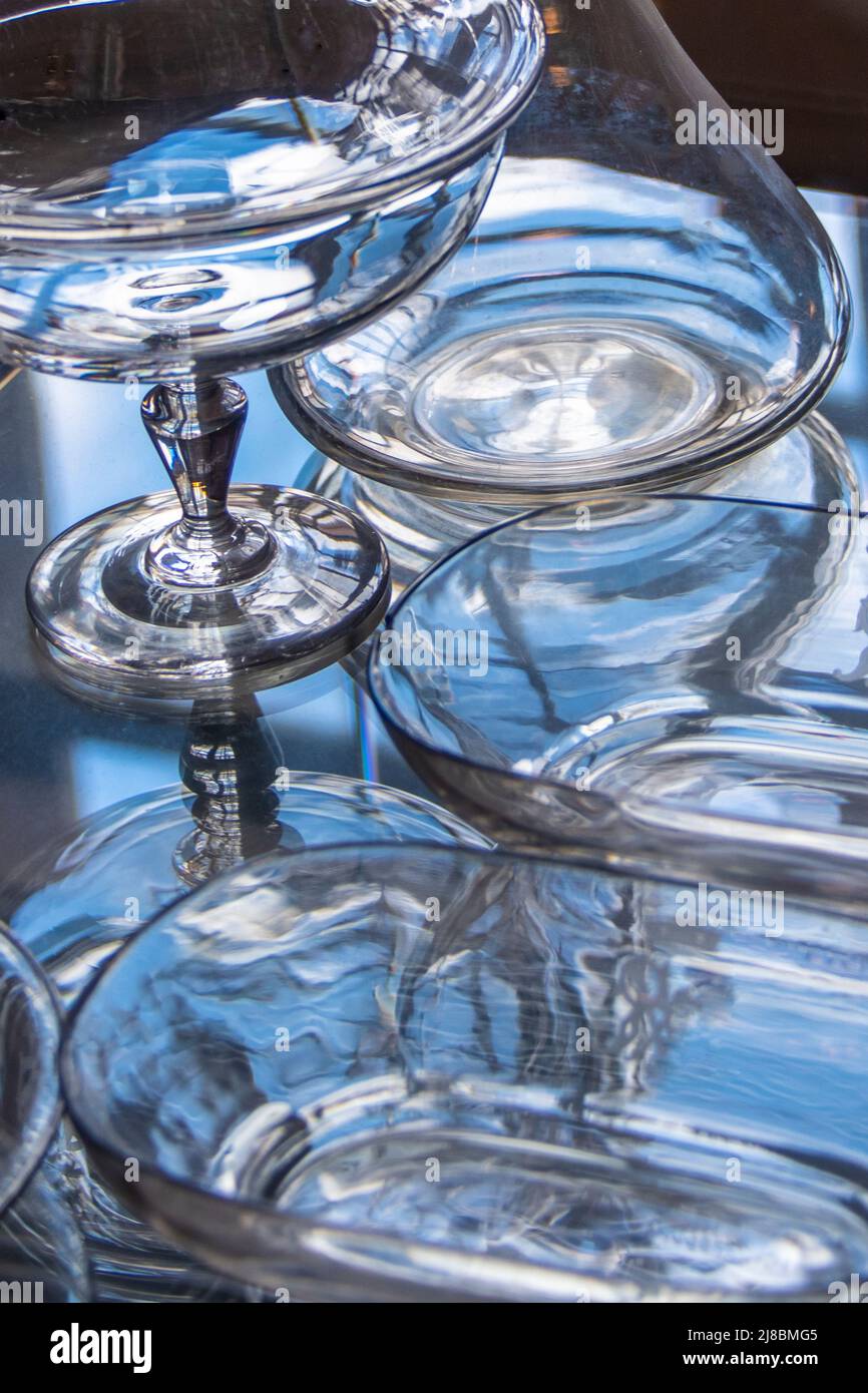 Glass ware in many different shapes unter the blue light of the day Stock Photo