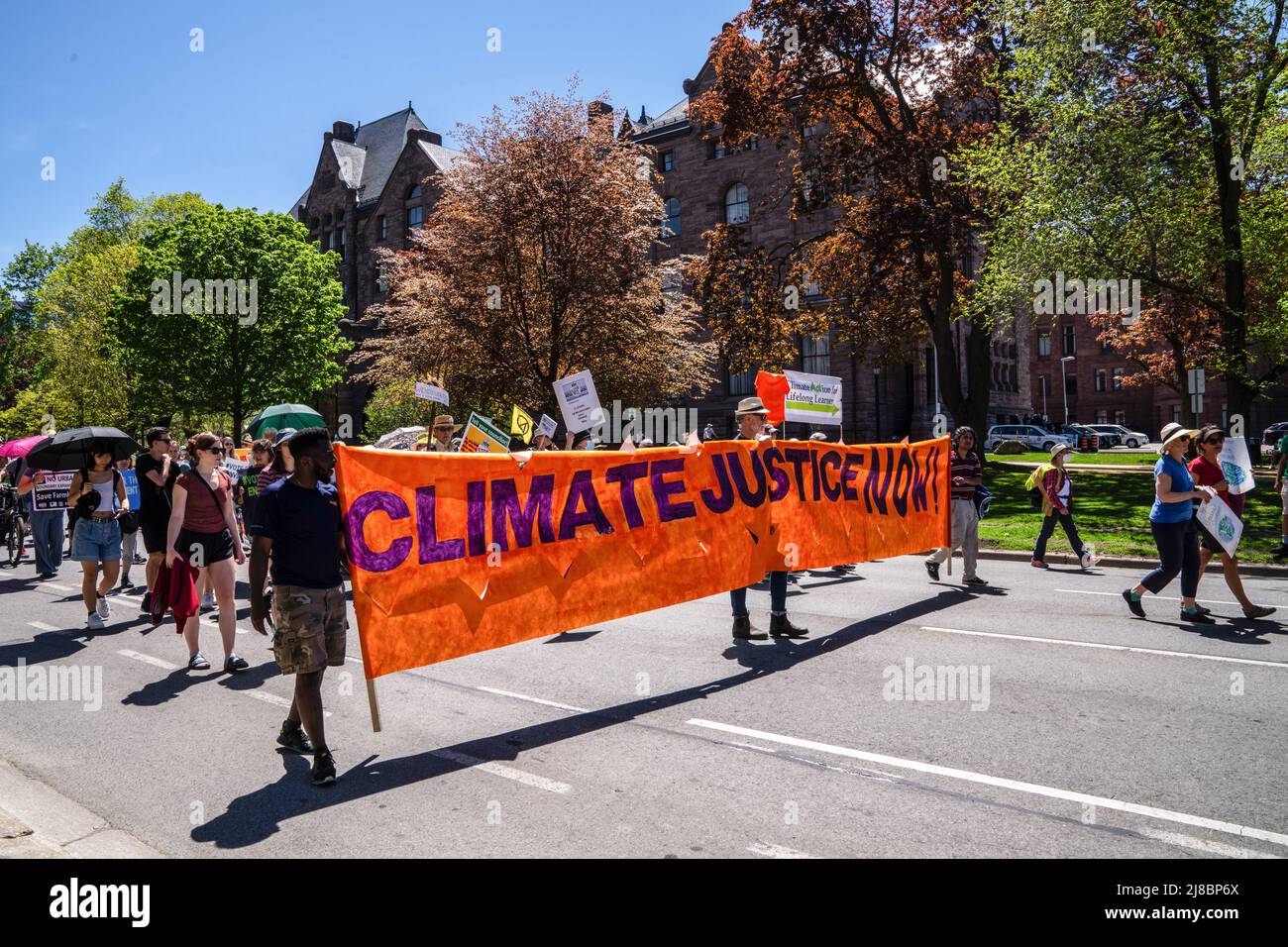 Climate Rally Graphics Activists march with a large banner that says