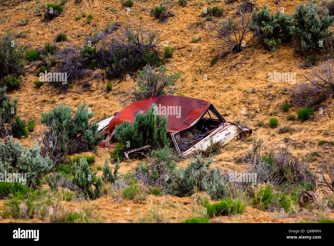 Rusted car abandoned buried in desert Stock Photo - Alamy