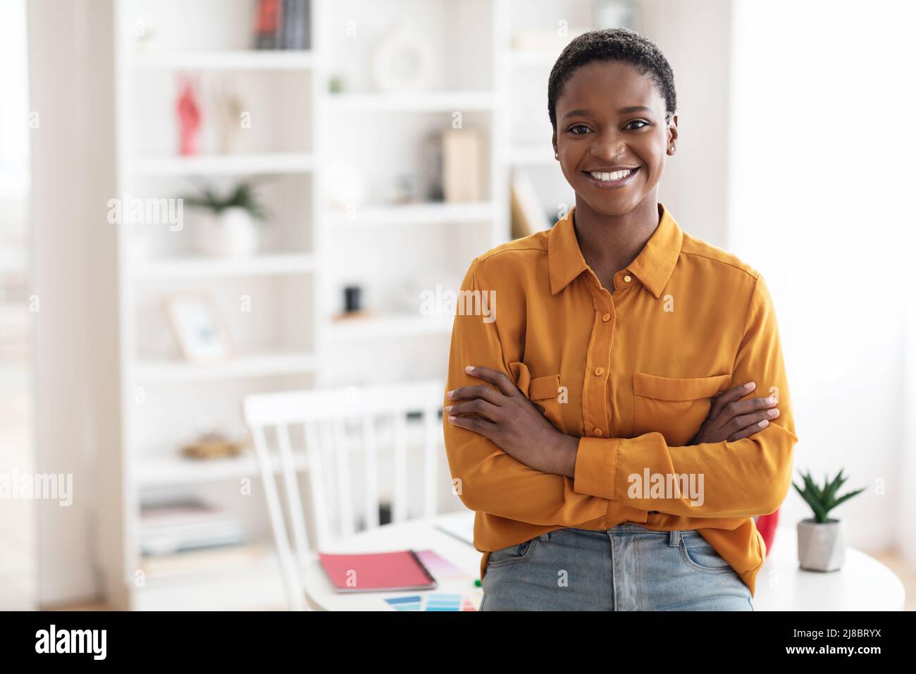 Portrait of positive african american lady posing at workplace Stock ...