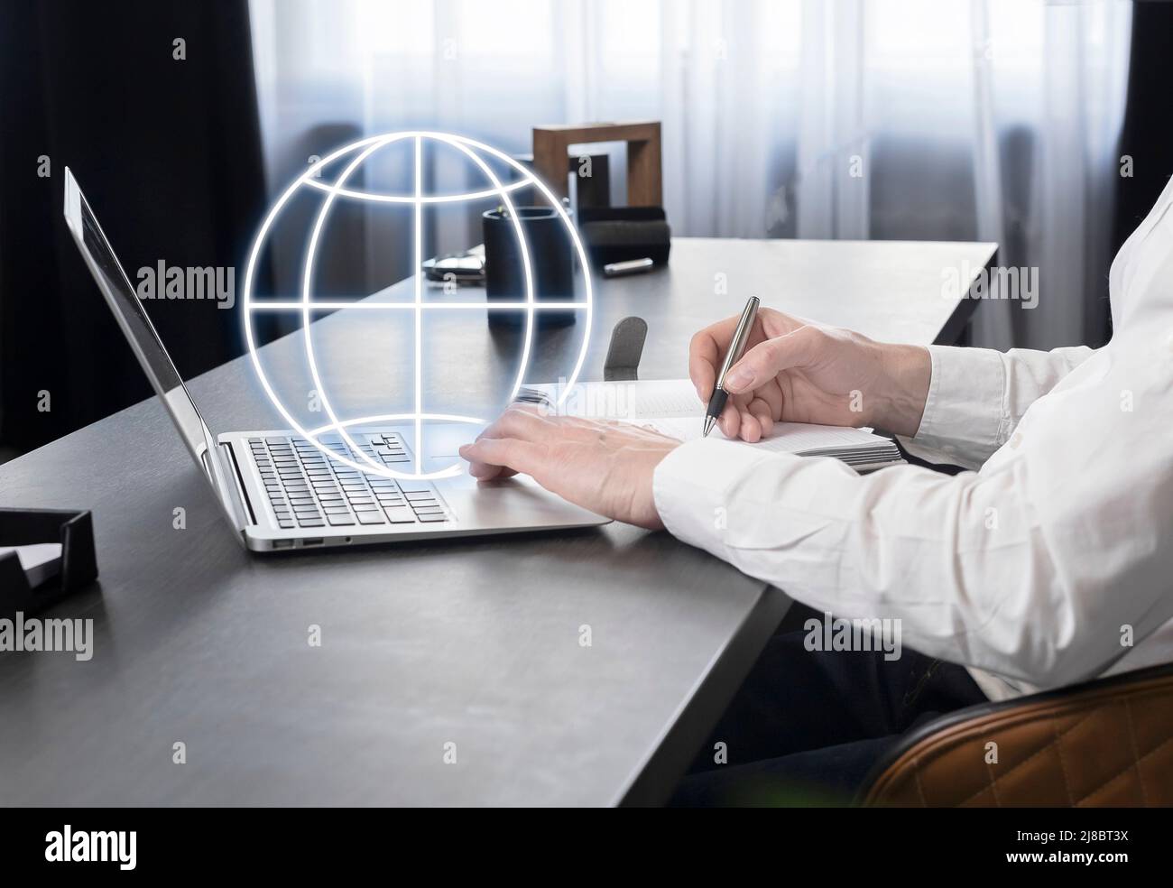 Businessman working on laptop, searching information on Internet, taking notes in planner, analyzing global market or communicating with international partners. High quality photo Stock Photo