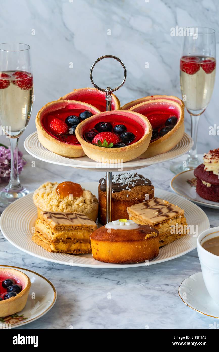 Selection of gourmet cakes with coffee and sparkling wine on a table Stock Photo