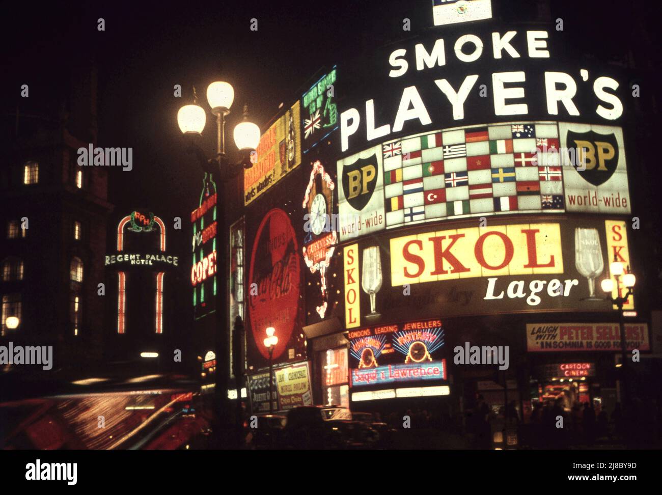 Piccadilly Circus at night in 1957 Note the cigarette advertising and the Peter Sellers movie Insomnia adverts/  Photo by Tony Henshaw Archive Stock Photo