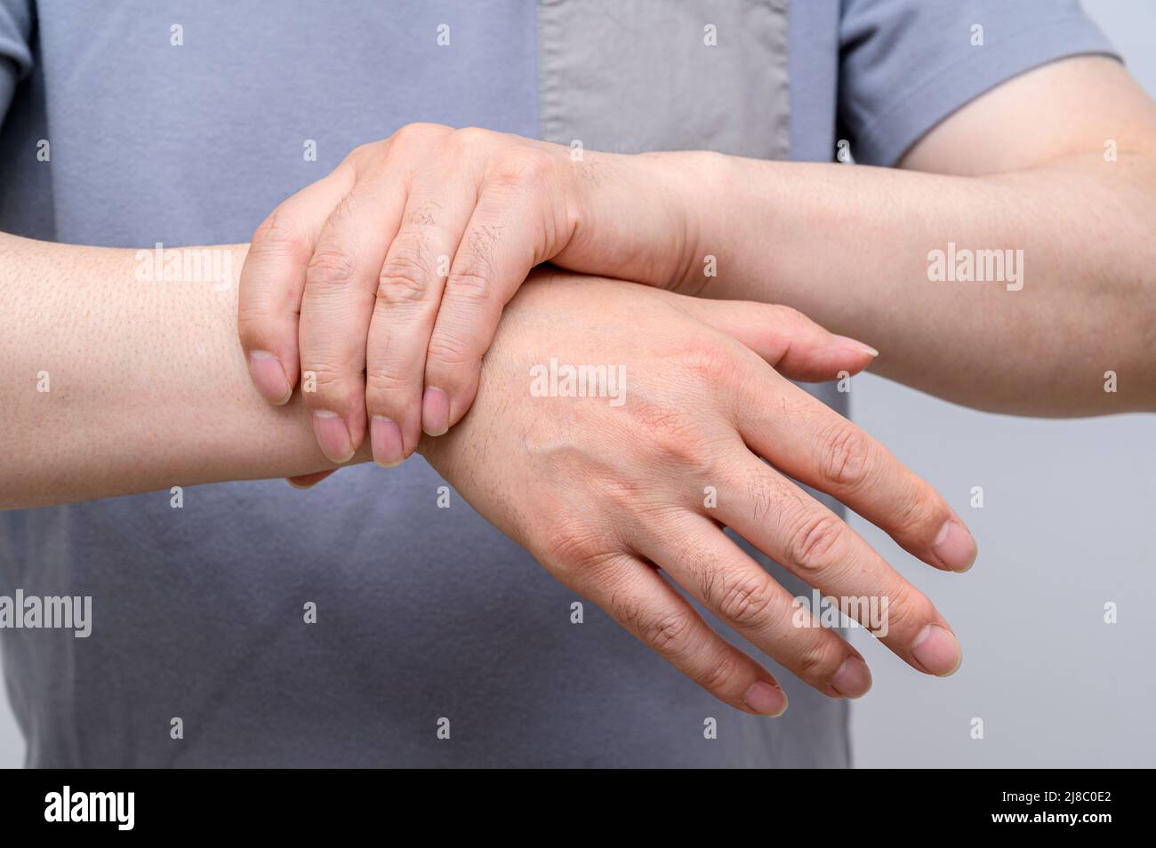 A man wrapped around his wrist because of wrist pain. Causes of rheumatoid arthritis, carpal tunnel syndrome, gout. Health care and medical concept. Stock Photo