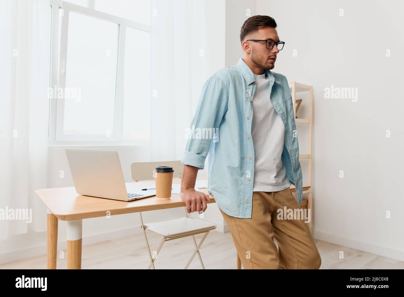 Focused serious handsome stylish young businessman in eyewear looks