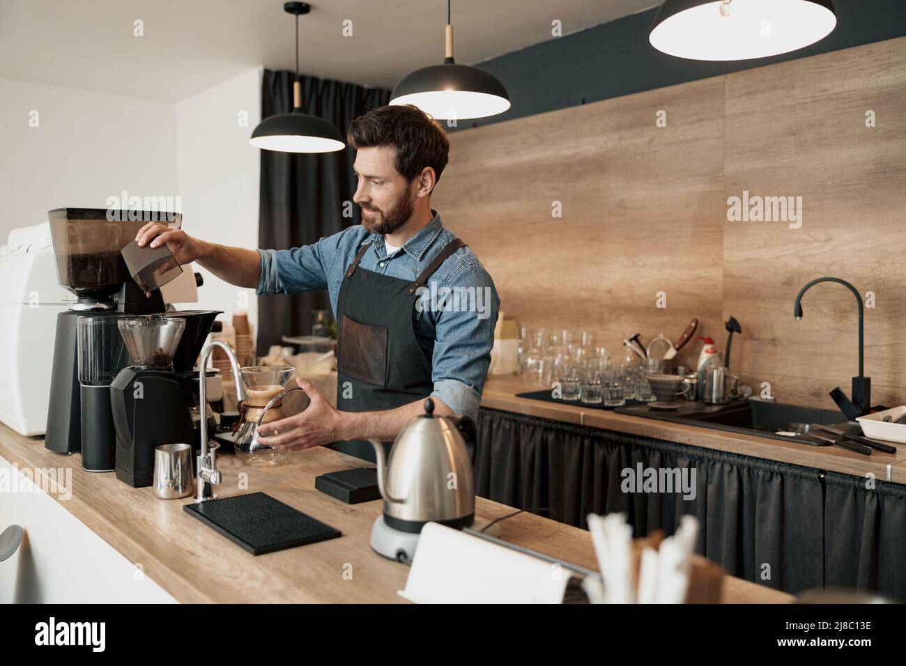 Barista grinds coffee beans before making coffee Stock Photo Alamy