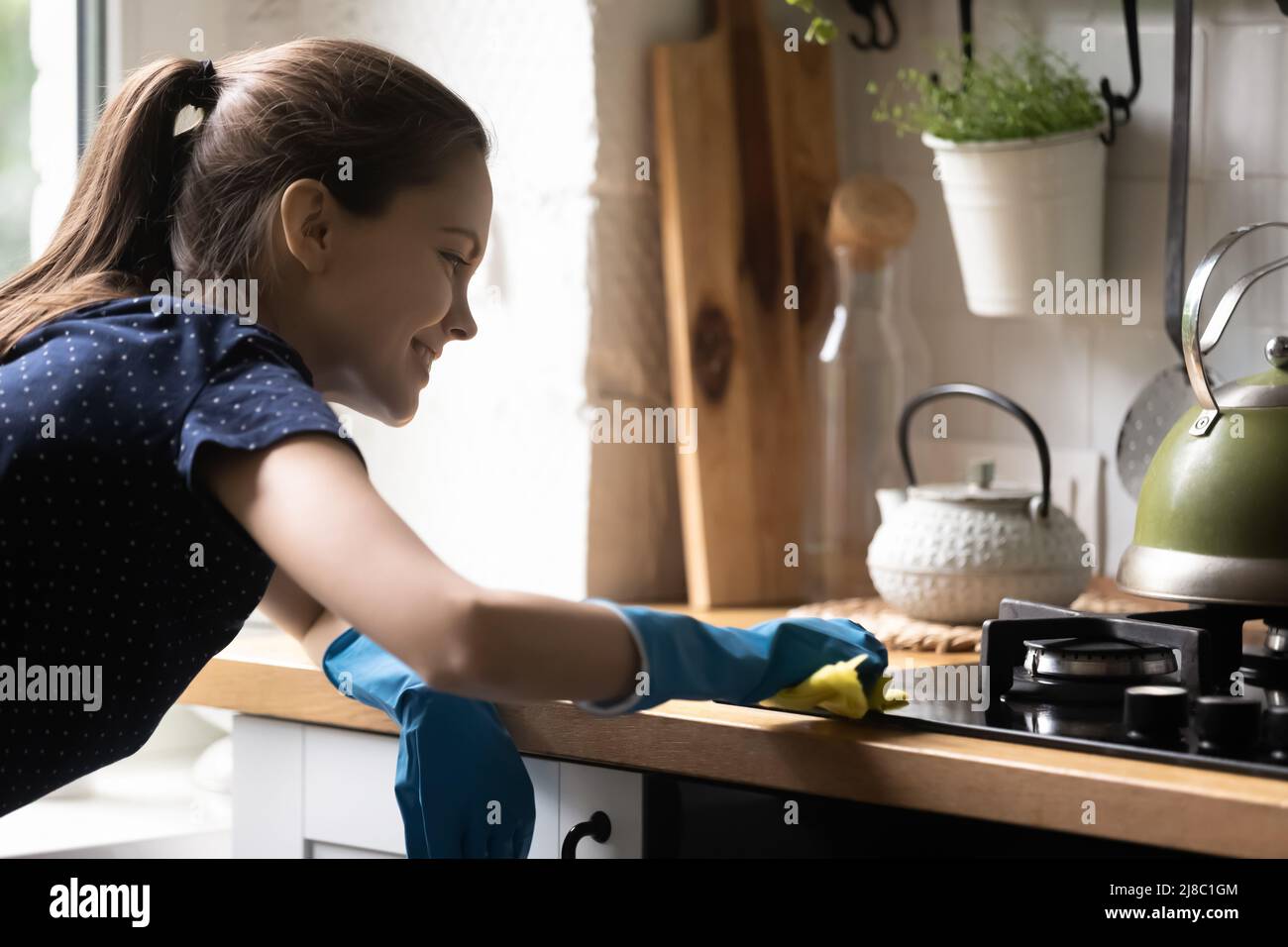 Happy tenant girl using blue protective rubber gloves Stock Photo