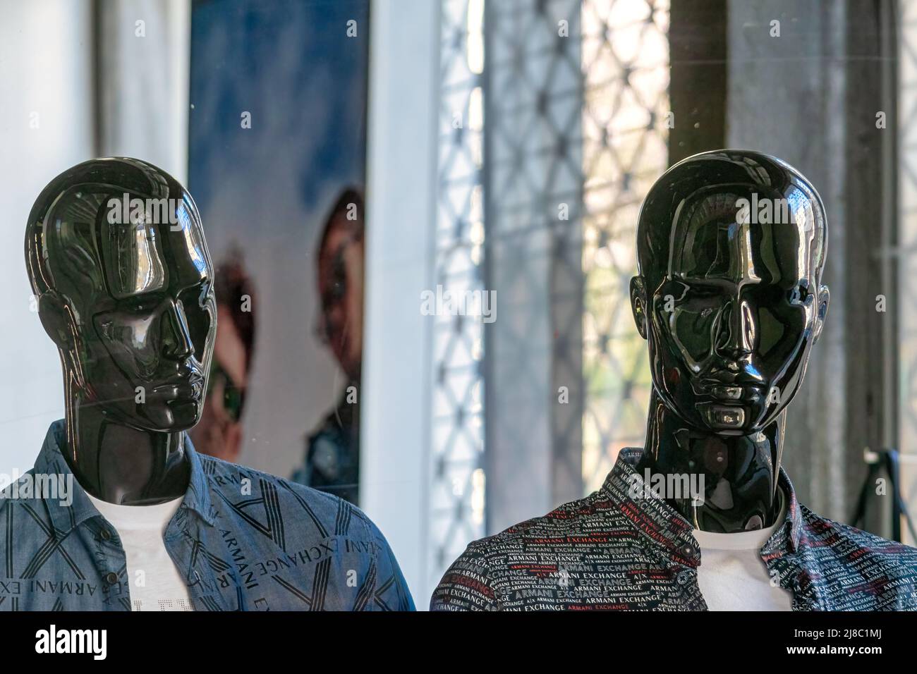Two black mannequins with a male likeness are seen in a retail store