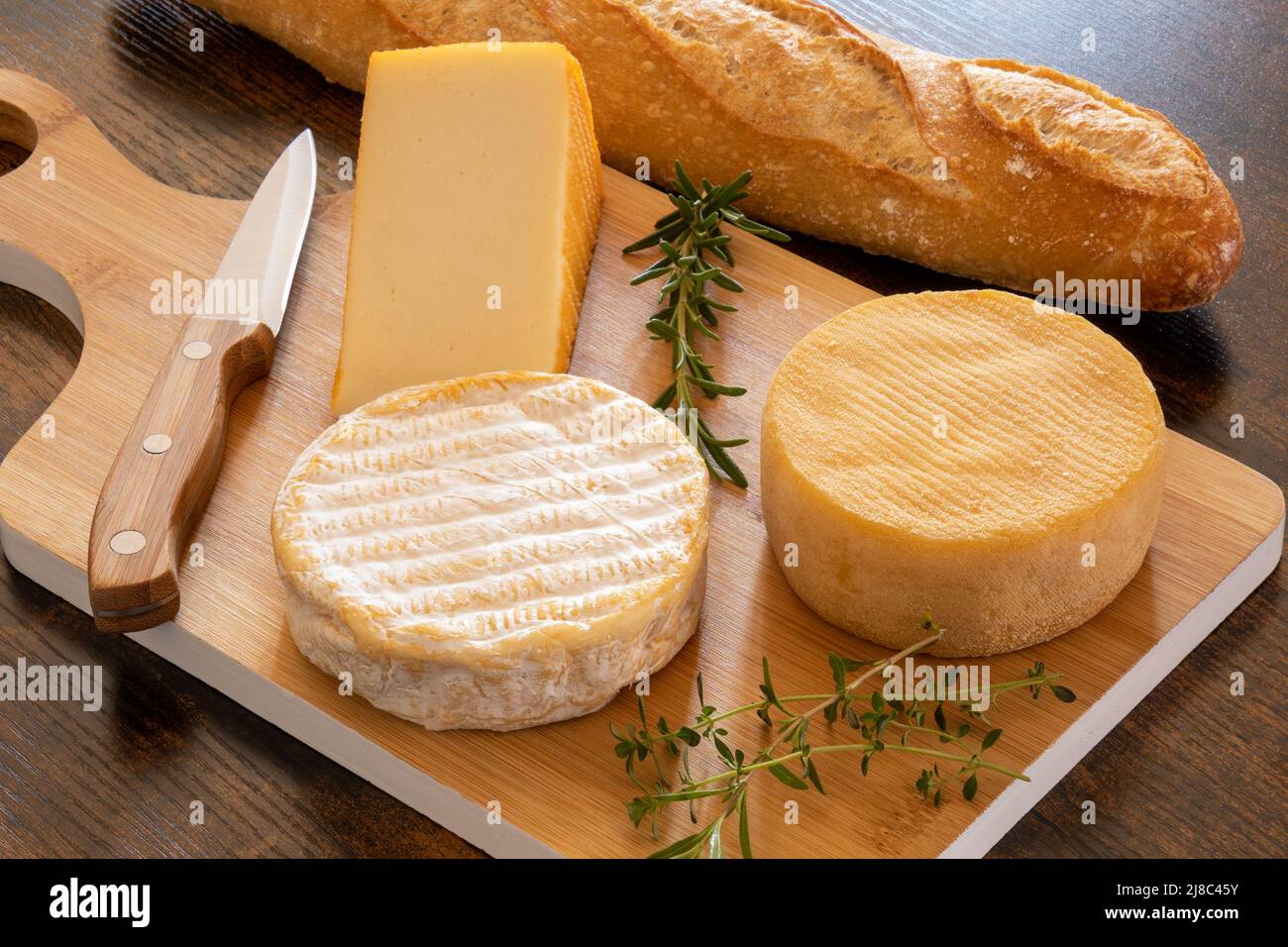 cheese platter with a baguette on a table Stock Photo
