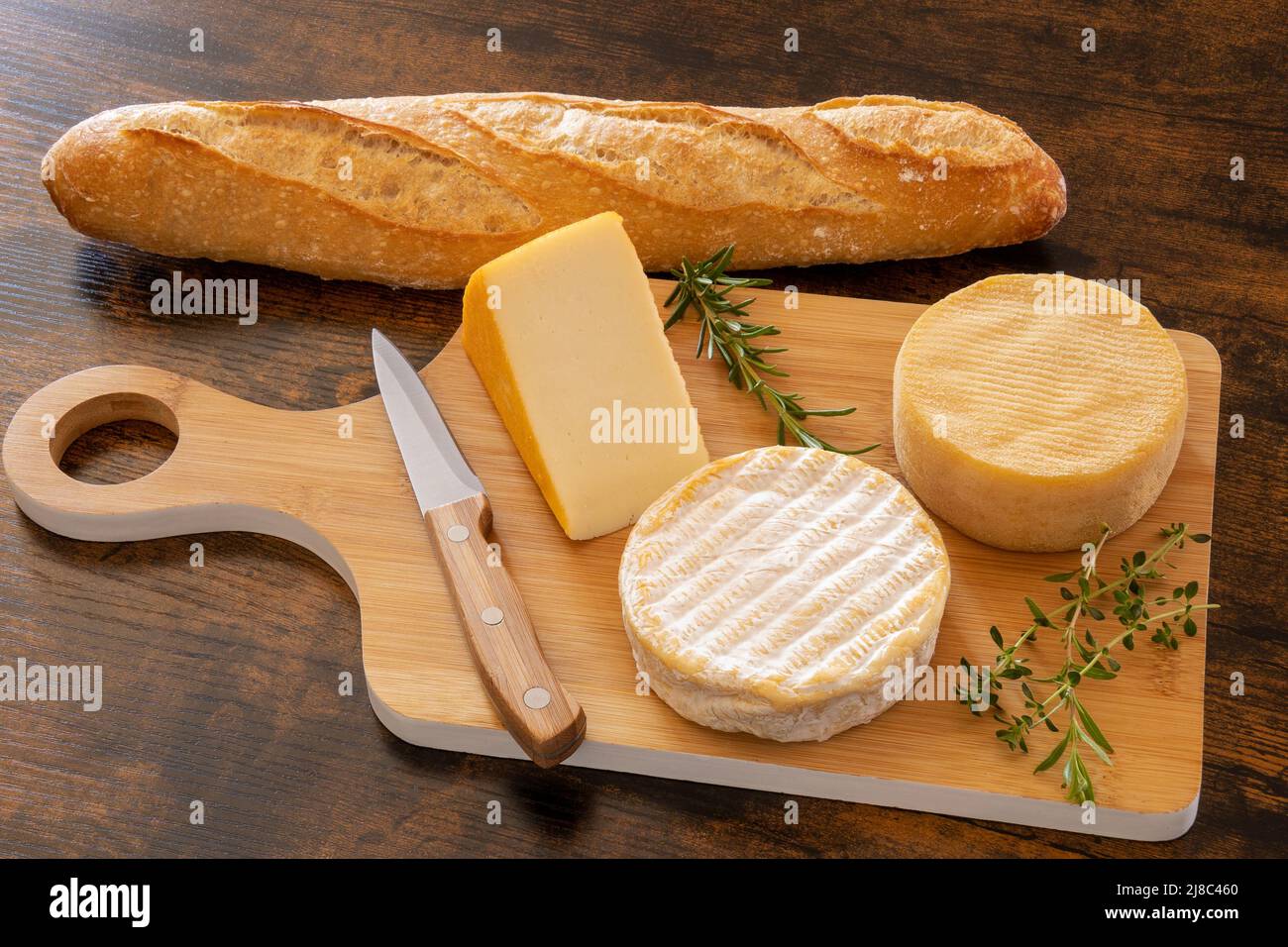 cheese platter with a baguette on a table Stock Photo