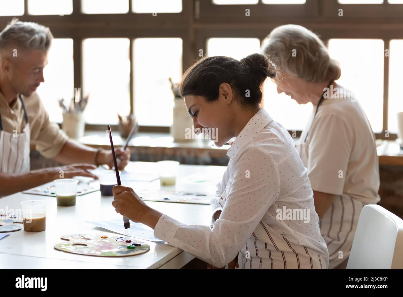 Multiracial painters engaged in painting art class in modern workshop Stock Photo