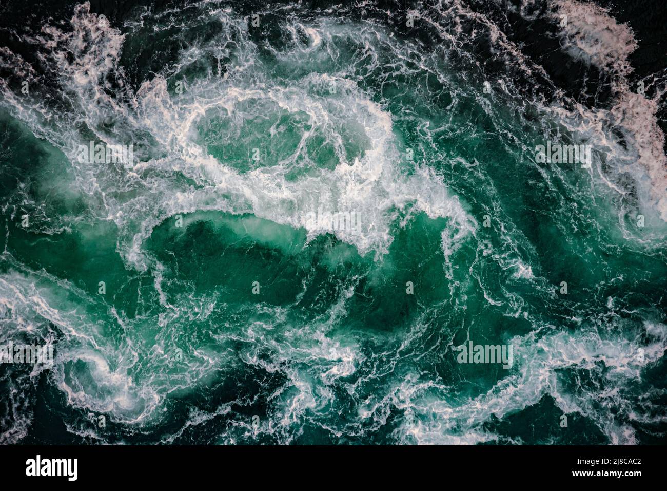Waves of water of the river and the sea meet each other during high tide and low tide. Whirlpools of the maelstrom of Saltstraumen, Nordland, Norway Stock Photo