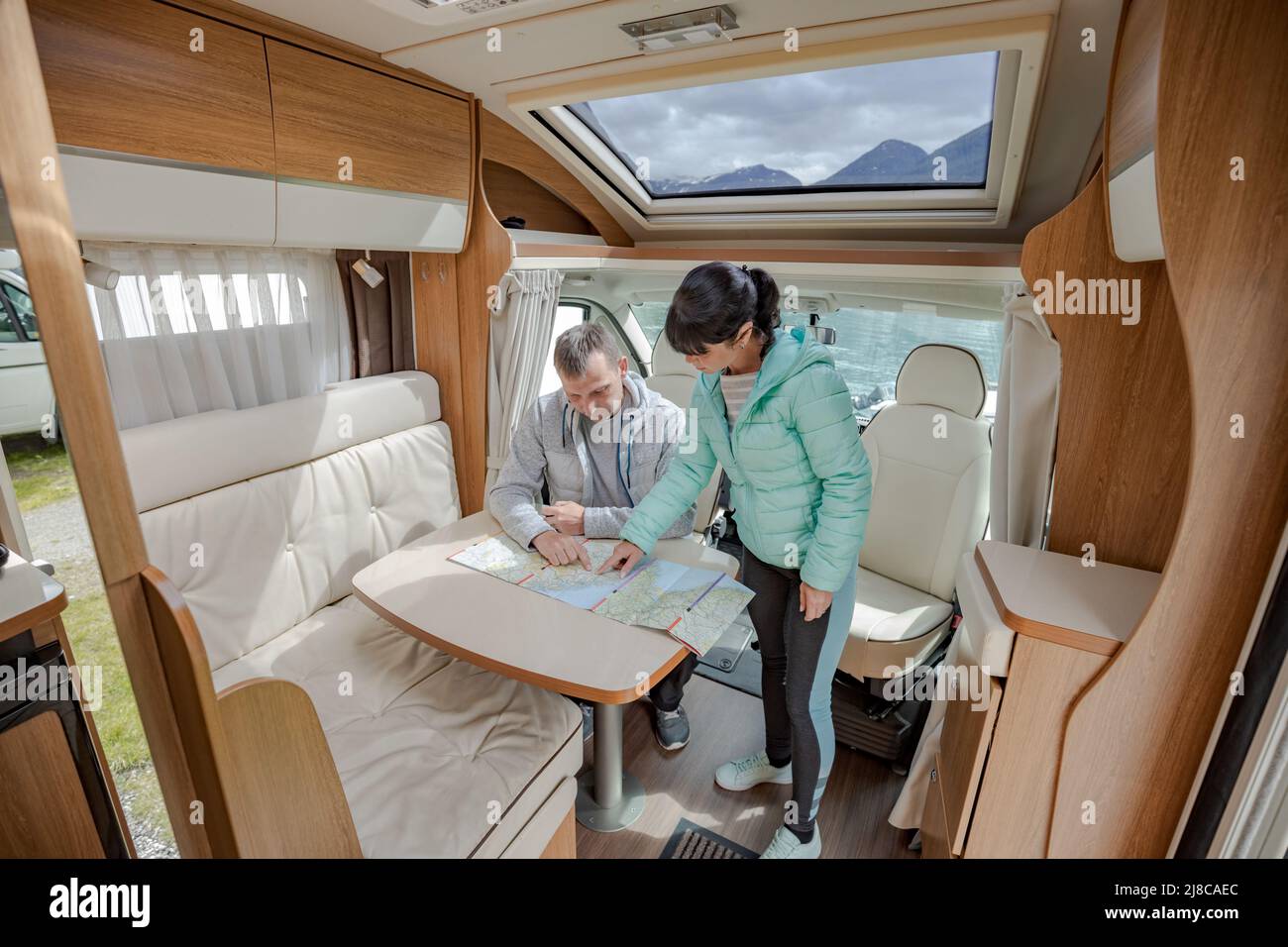 Couples in RV Camper looking at the local map for the trip. Family vacation travel, holiday trip in motorhome, Caravan car Vacation. Stock Photo