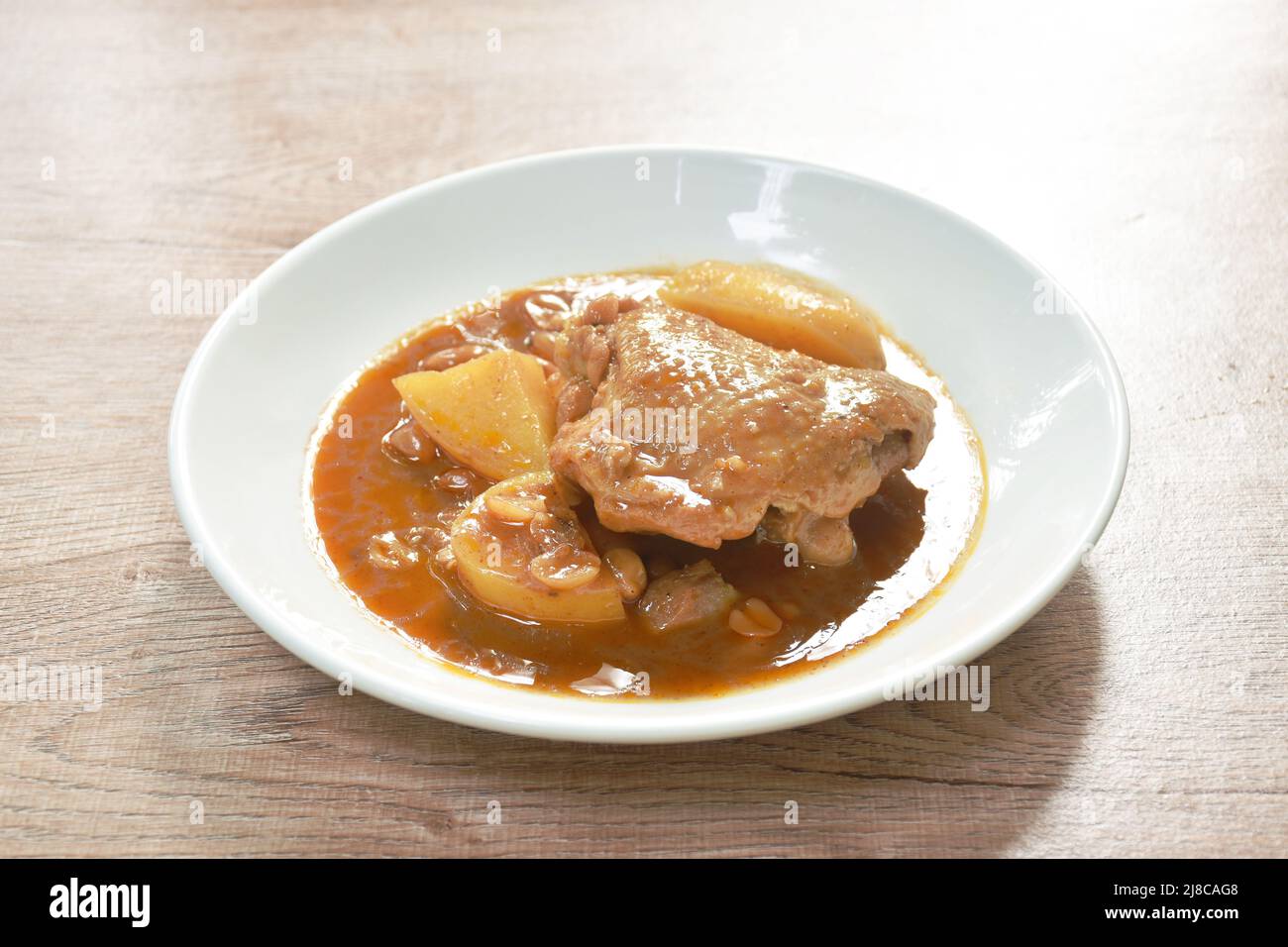 chicken thigh massaman curry with slice potato and peanut on plate Stock Photo