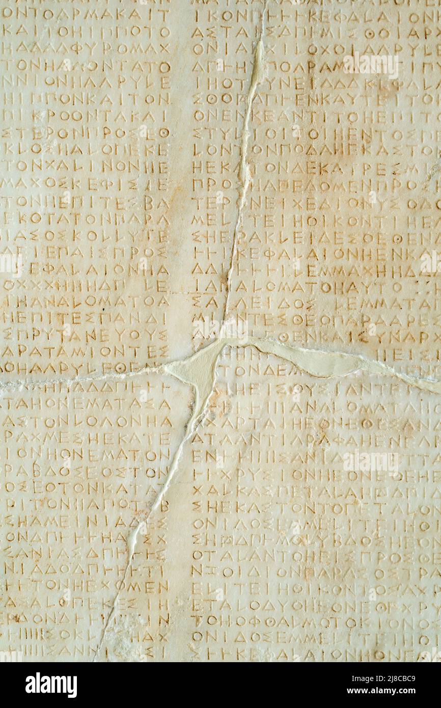 Texture written in antique Greek letters on a stone wall Stock Photo