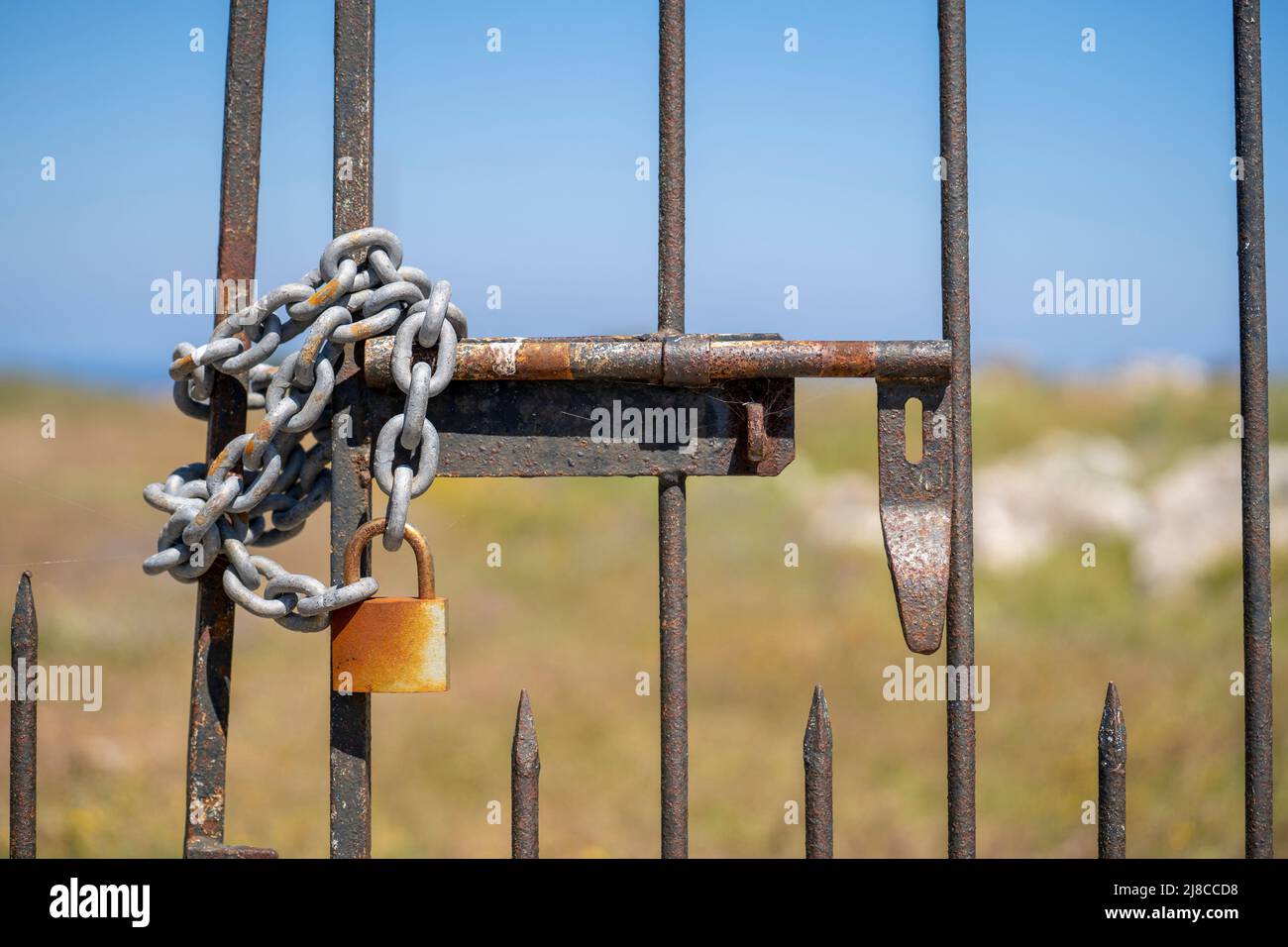 Rusty exterior iron lock of a iron door  of a agricultural land. Stock Photo