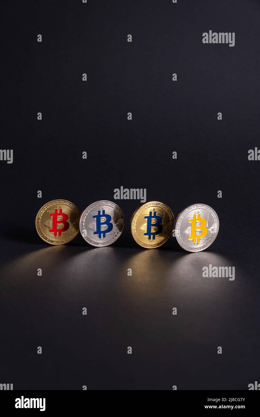 Four Bitcoin coins with different colour, aligned on a black background. BTC Crypto digital currency coin International stock exchange. Stock Photo