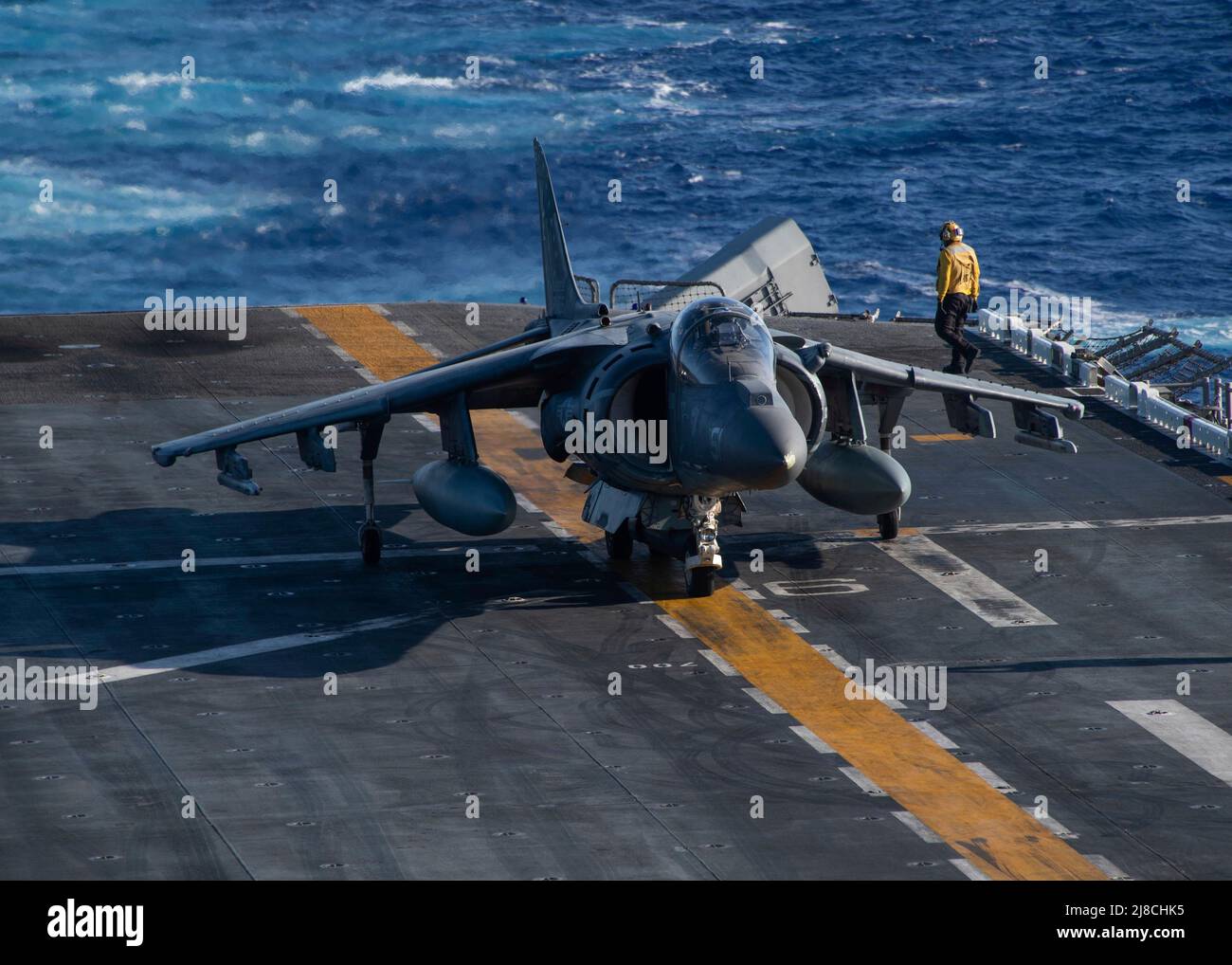 A U.S. Marine Corps AV-8B Harrier fighter aircraft, attached to the Black Sheep of Marine Attack Squadron 214, prepares to take off from the flight deck of the Wasp-class amphibious assault ship USS Essex, February 14, 2022 operating on the Pacific Ocean. Stock Photo