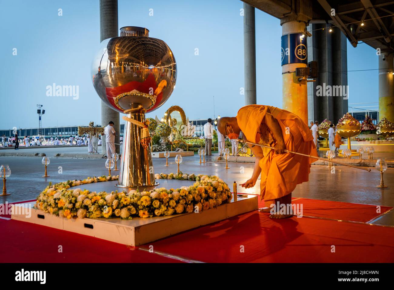 Pathum Thani, Thailand, May 15, 2022. A monk prepares a torch to be lit prior to a ceremony at a temple. Wat Phra Dhammakaya commemorates International Vesak Day (Visakha Bucha) by lighting 210,000 LEDs depicting the Lord Buddha's Birth, Enlightenment, and Great Decease. Matt Hunt/Neato. Stock Photo