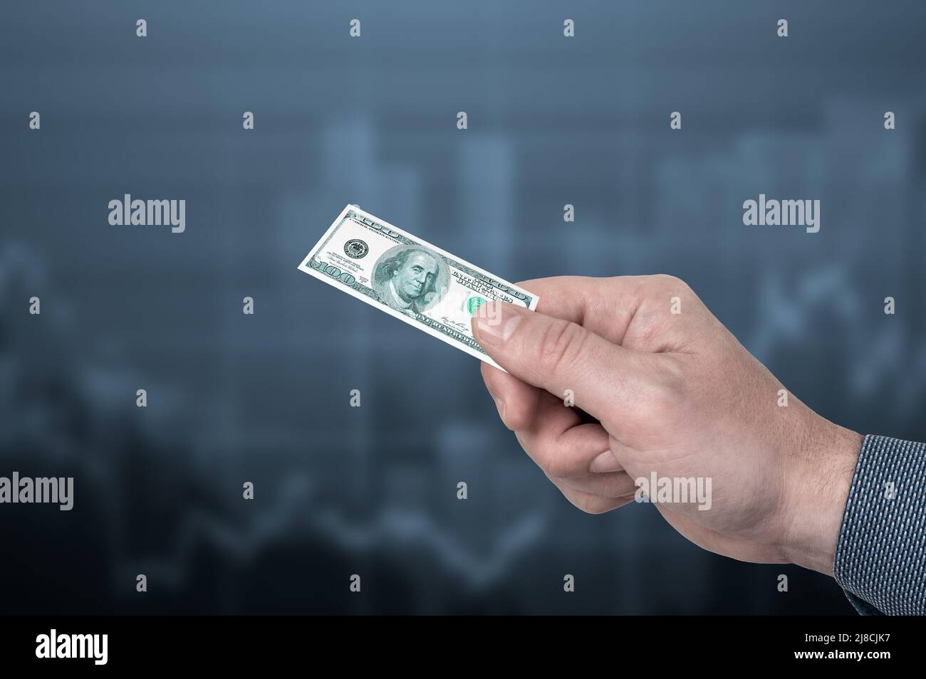 inflation. man holds small one hundred dollar bill in his hand, symbol of inflation. concept of decreasing purchasing power, inflation. inflation in u Stock Photo