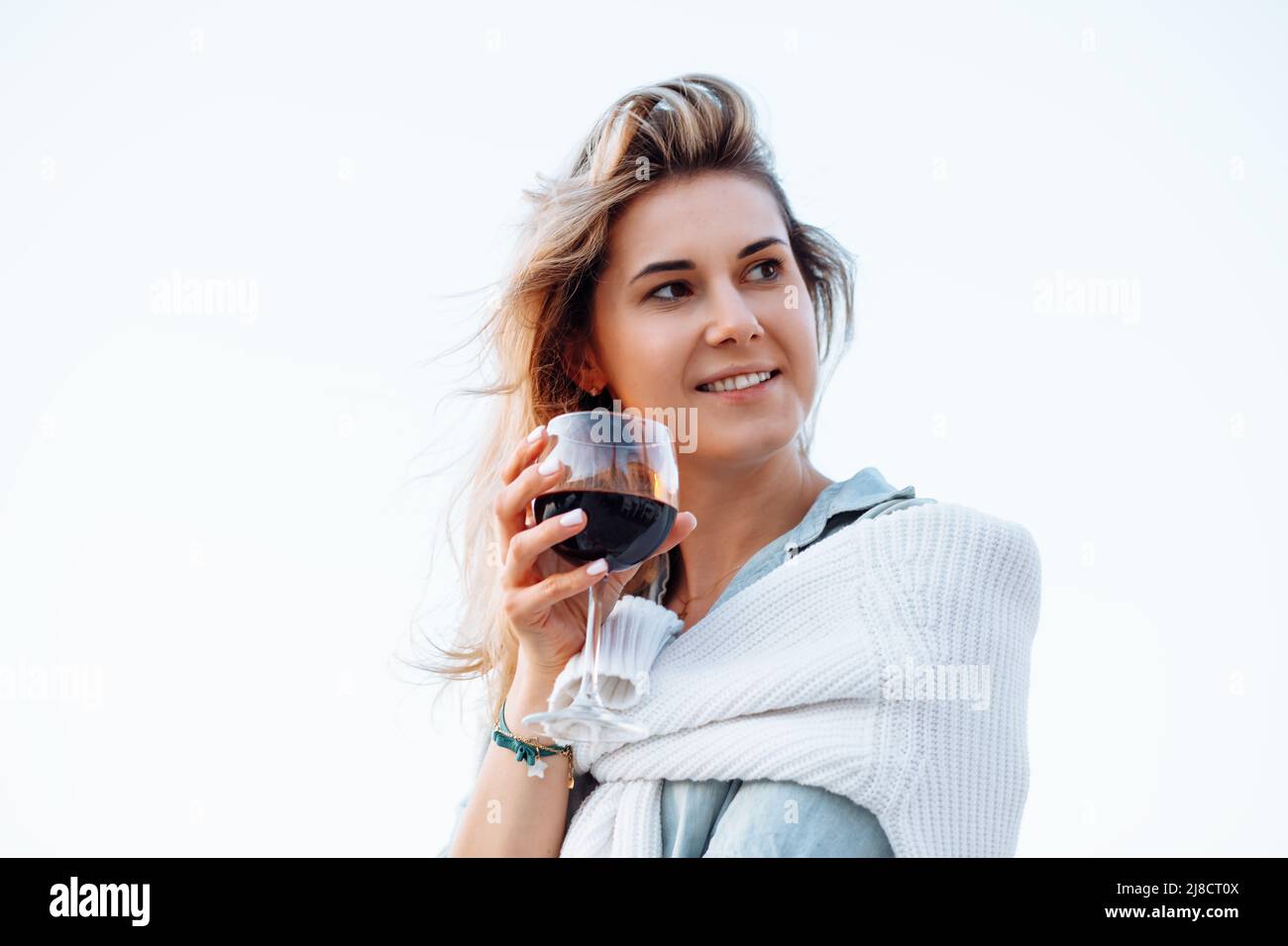 Portrait of happy woman holding in hand wine glass and drinking red ...