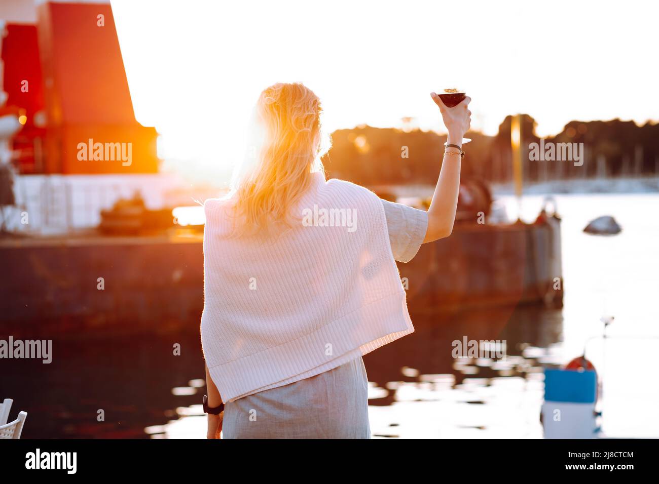 Portrait of woman holding in hand wine glass and drinking red wine at ...