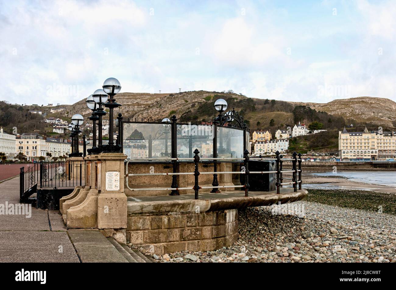 Early 20th century concrete iron and stone Llandudno bandstand with a semi circular rear wall to the podium and a semi-circular walkway with railings Stock Photo