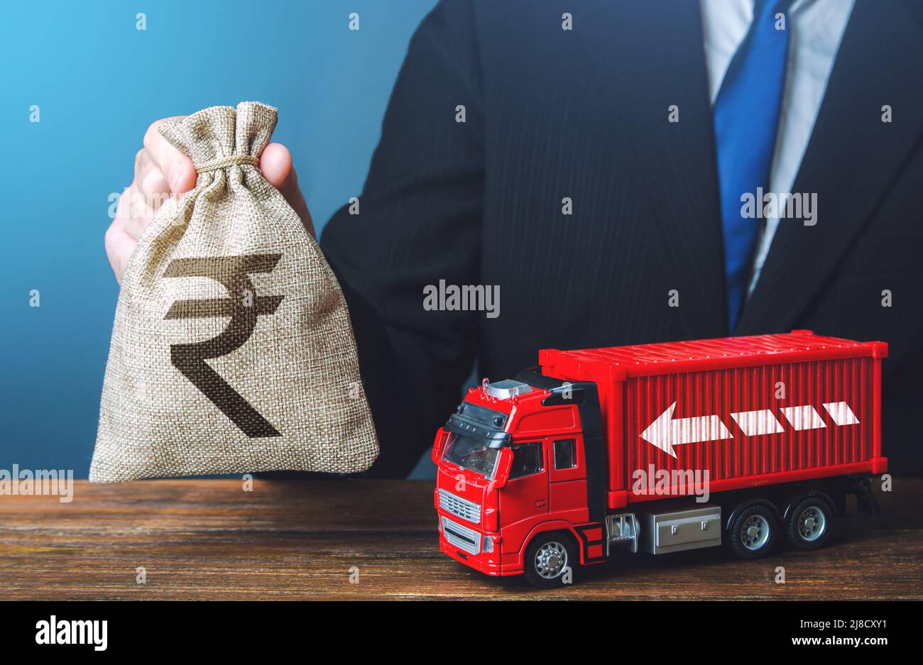 Businessman with indian rupee money bag and truck. Good salaries for drivers. Rising prices, global containers shortage crisis. High income of the tra Stock Photo