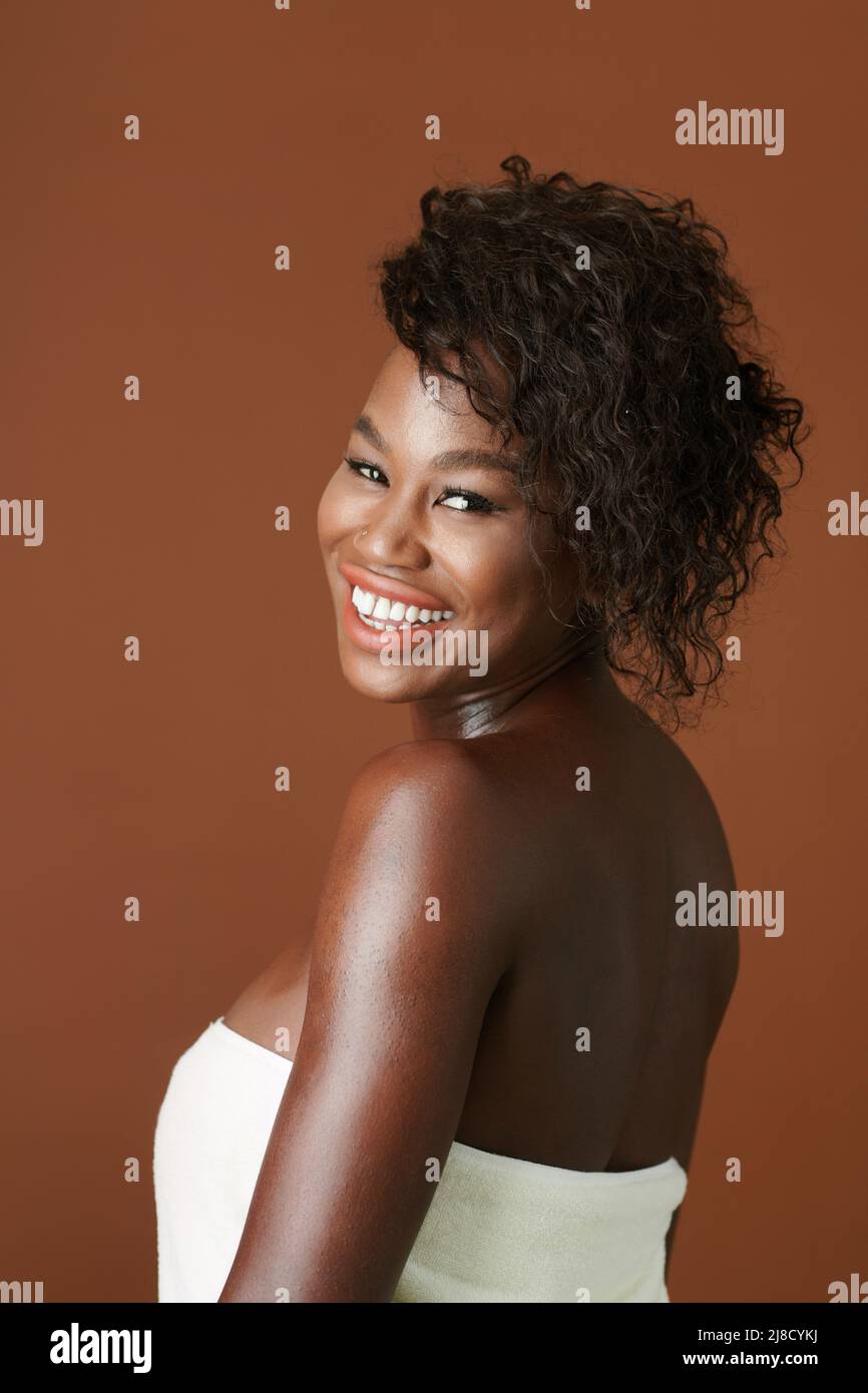 Portrait of smiling pretty young woman wrapped in bath towel 