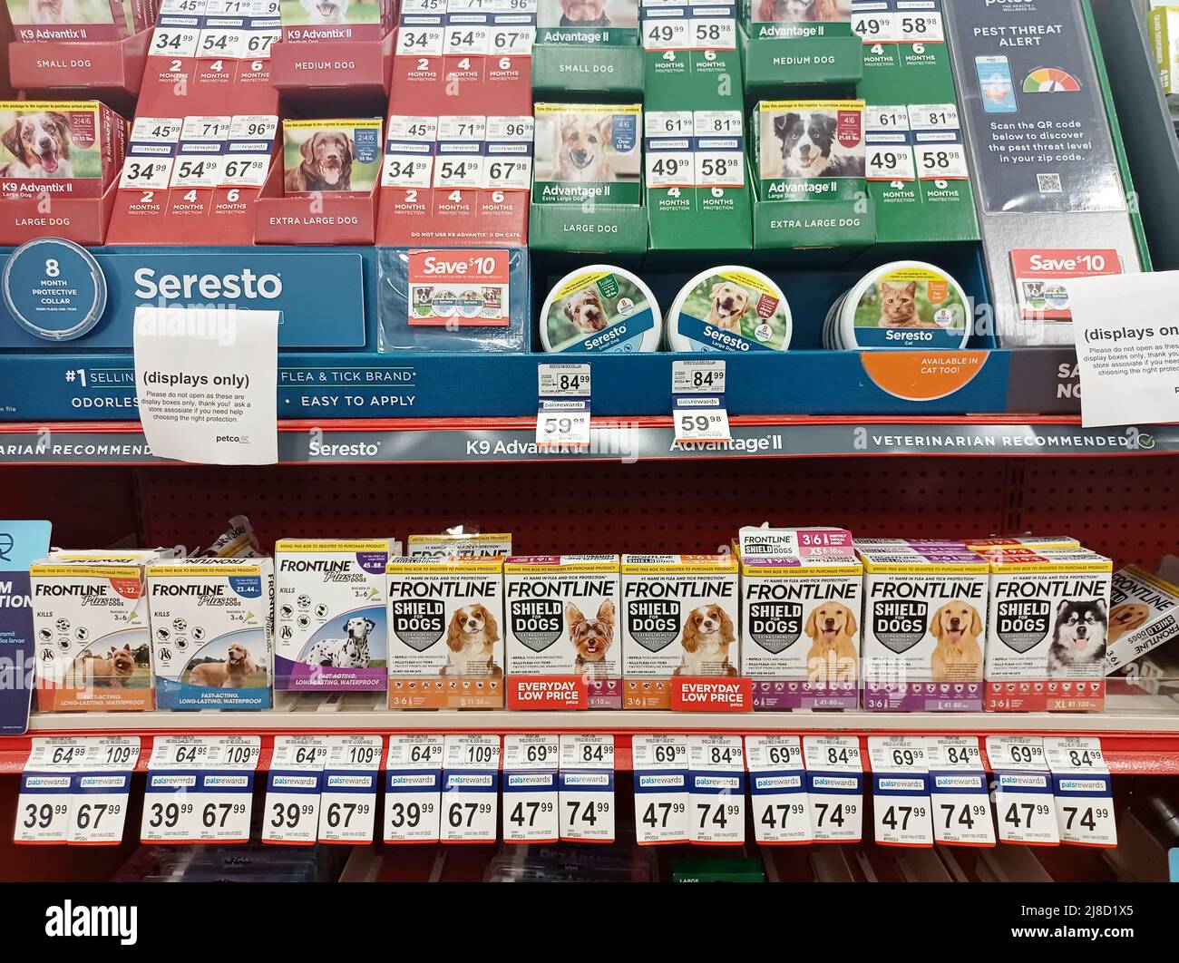 Various dog flea treatment medication brands displayed on shelves in a pet store. Stock Photo