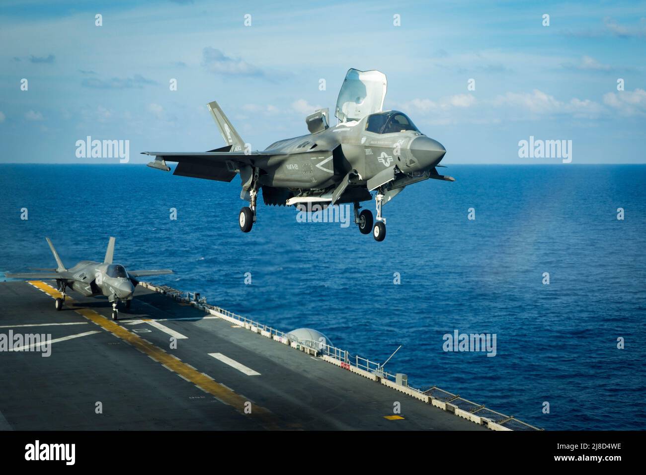 A U.S. Marine Corps F-35B Lightning II fighter aircraft, attached to the Dragons of Marine Medium Tiltrotor Squadron 265, performs a vertical landing on the flight deck of the America-class amphibious assault ship USS America, April 18, 2020 operating on the South China Sea. Stock Photo