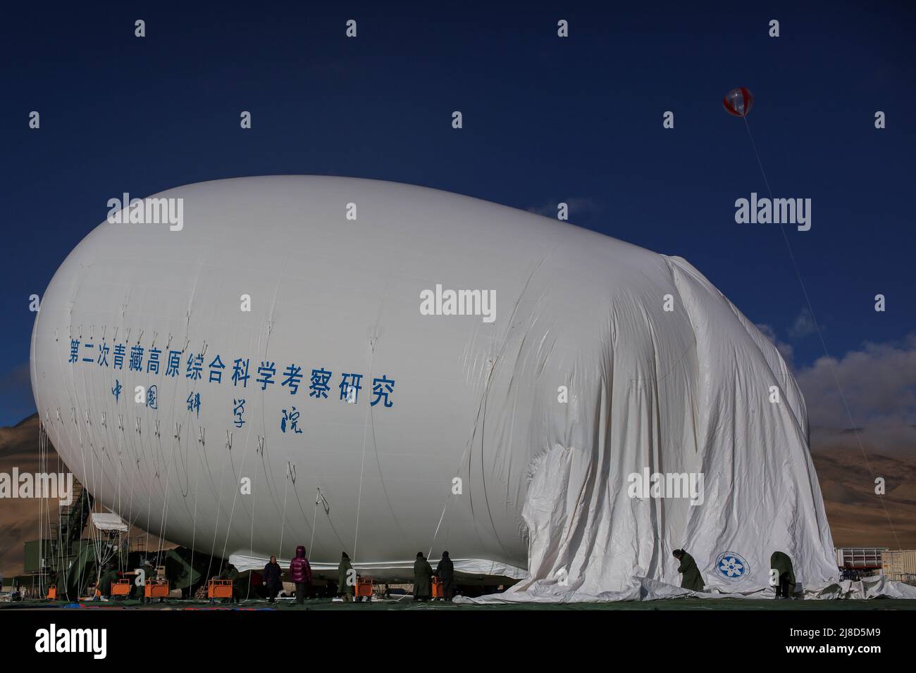 (220515) -- MOUNT QOMOLANGMA BASE CAMP, May 15, 2022 (Xinhua) -- Floating airship 'Jimu No.1' type III is being inflated in Zhaxizom Township of Tingri County, southwest China's Tibet Autonomous Region, May 12, 2022. China's self-developed floating airship, designed for atmosphere observation, reached a record altitude of 9,032 meters in Tibet Autonomous Region on Sunday, according to its developer.   Developed by the Aerospace Information Research Institute of the Chinese Academy of Sciences (CAS), the floating airship 'Jimu No.1' type III has a volume of 9,060 cubic meters. (Xinhua/Jiang Fan Stock Photo