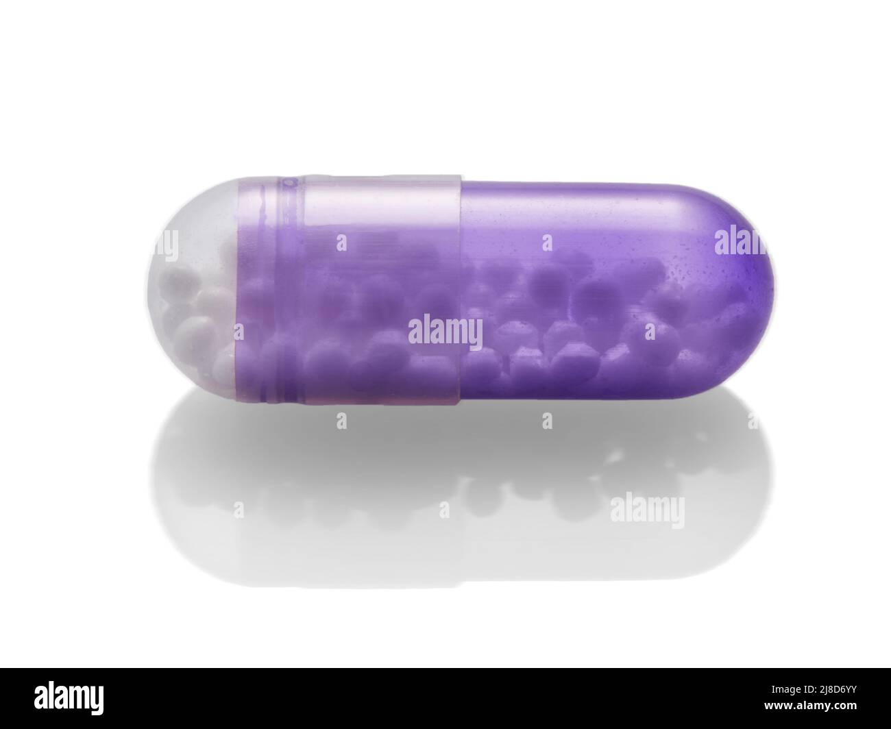 Purple capsule isolated on white background. Stock Photo