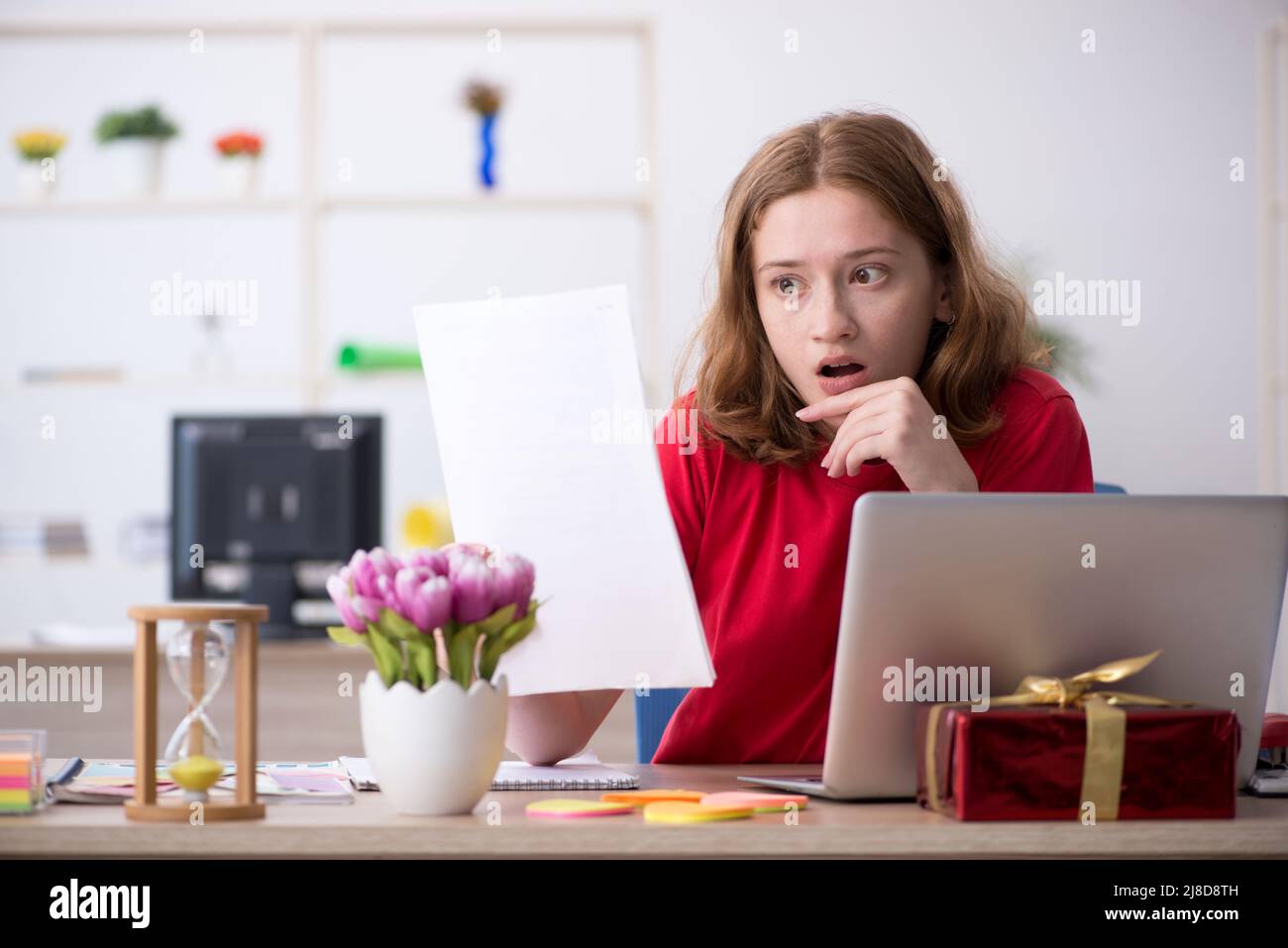 Young female designer celebrating Christmas at workplace Stock Photo