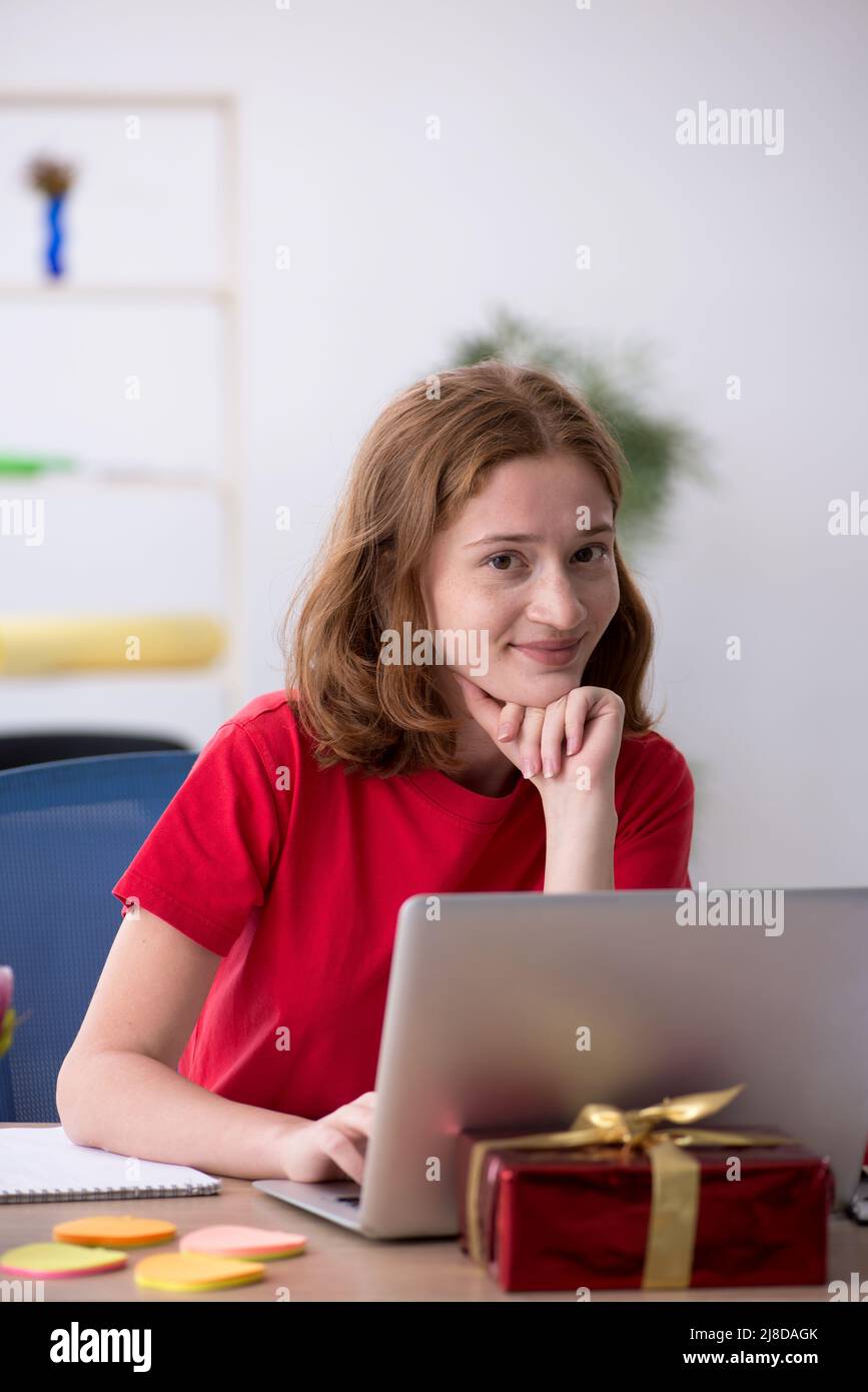 Young female designer celebrating Christmas at workplace Stock Photo