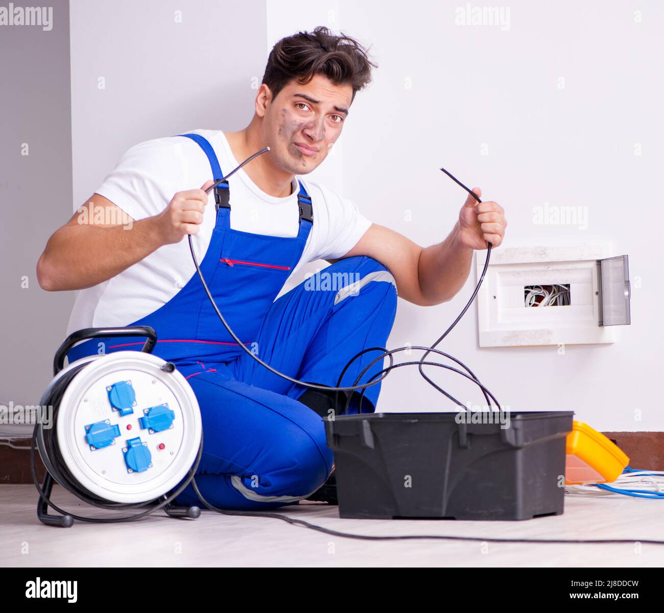 The funny man doing electrical repairs at home Stock Photo