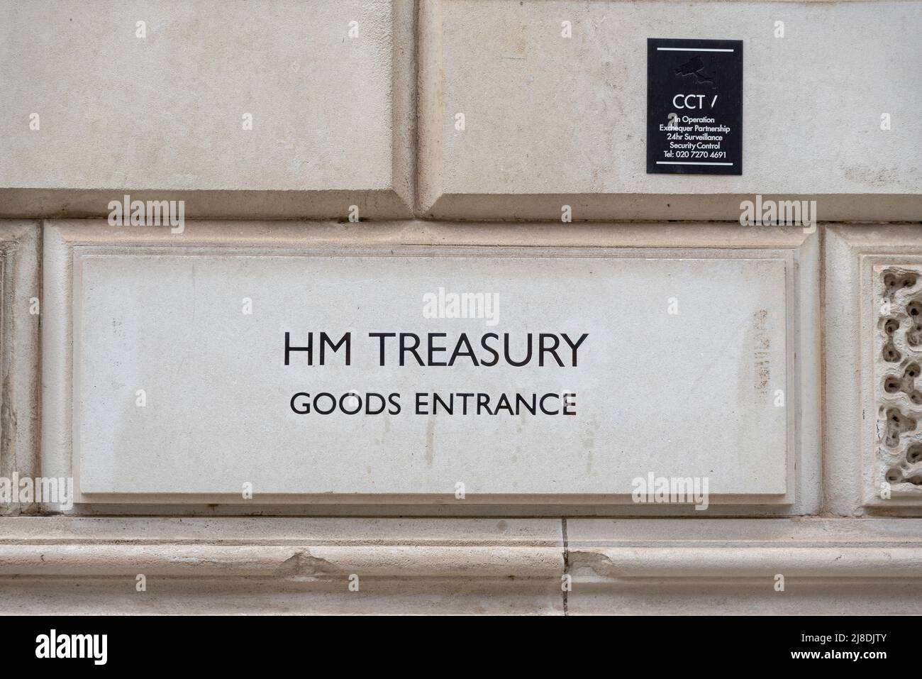 HM Treasury, goods entrance, carved stone sign. Her Majesty's Treasury government department, with CCTV security notice Stock Photo