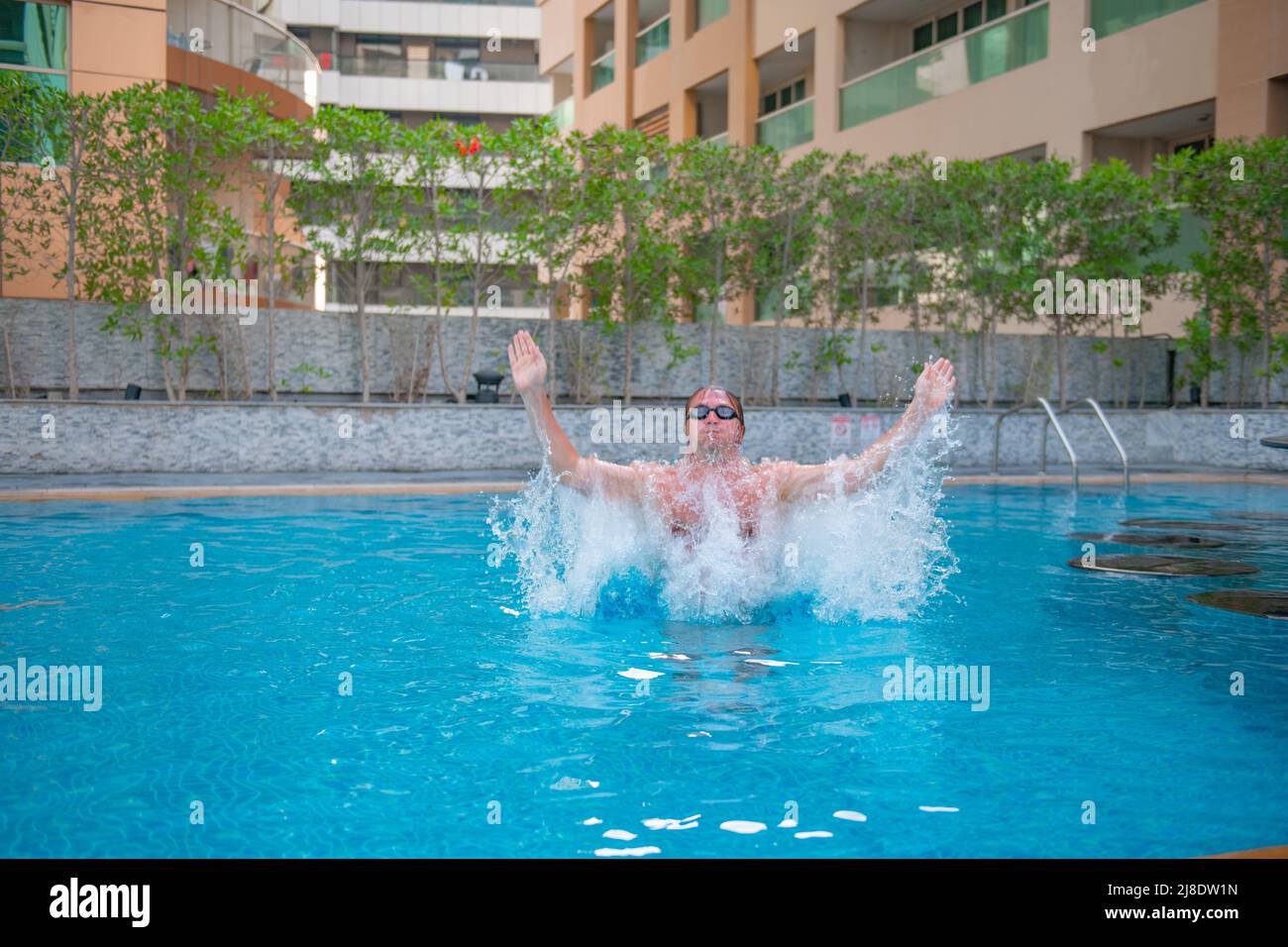 one boy is jumping up in the big pool Stock Photo
