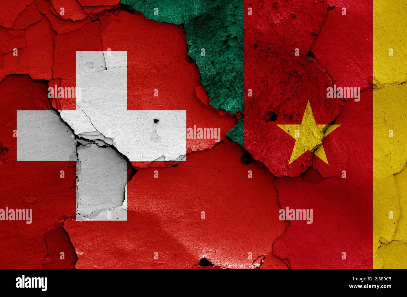 flags of Switzerland and Cameroon painted on cracked wall Stock Photo