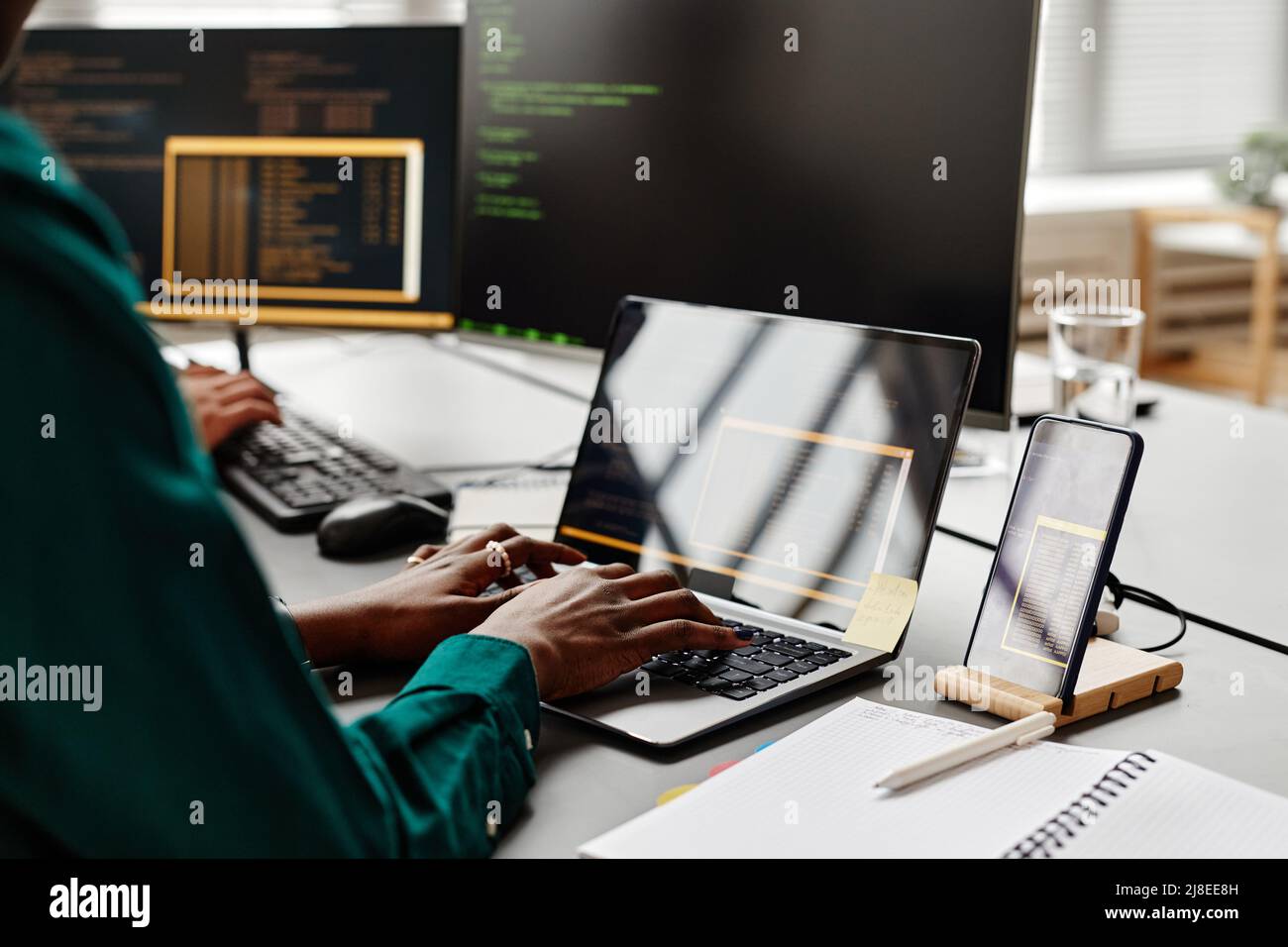 Closeup of female IT developer typing on keyboard while writing code at workplace in office, copy space Stock Photo