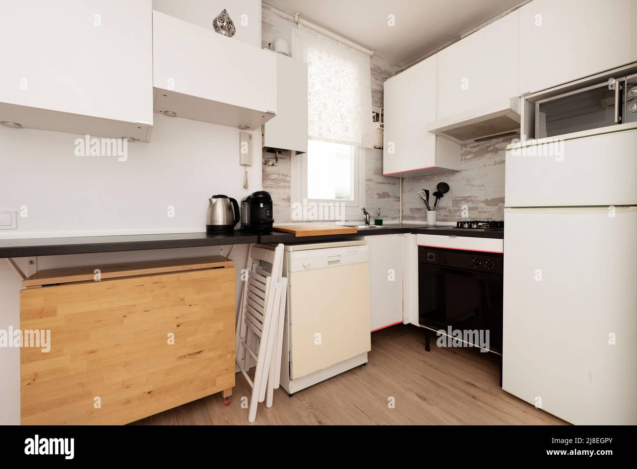 Kitchen with white black countertop, light hardwood floors