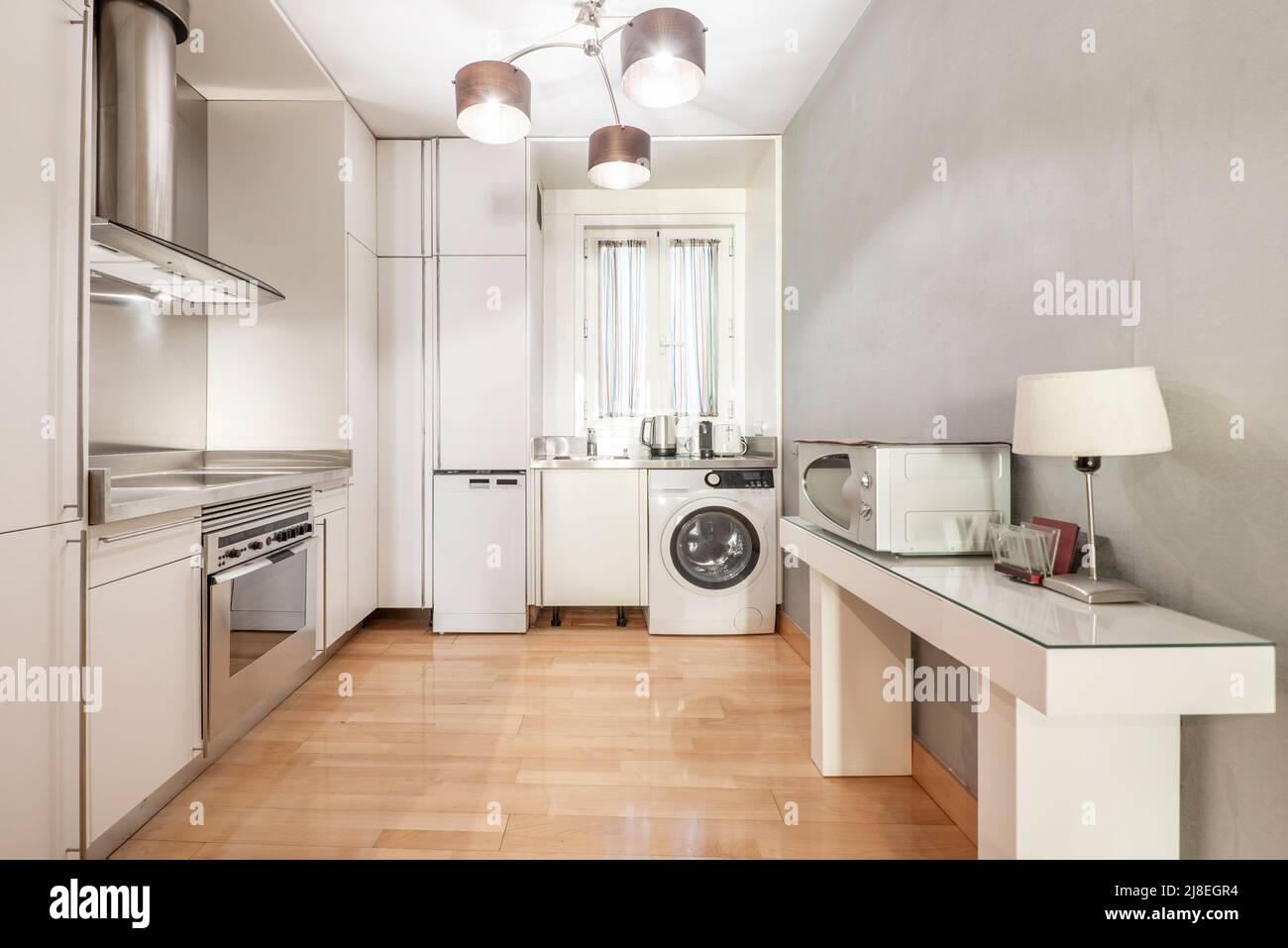 Luxury apartment kitchen with white cabinets, microwave and stainless ...