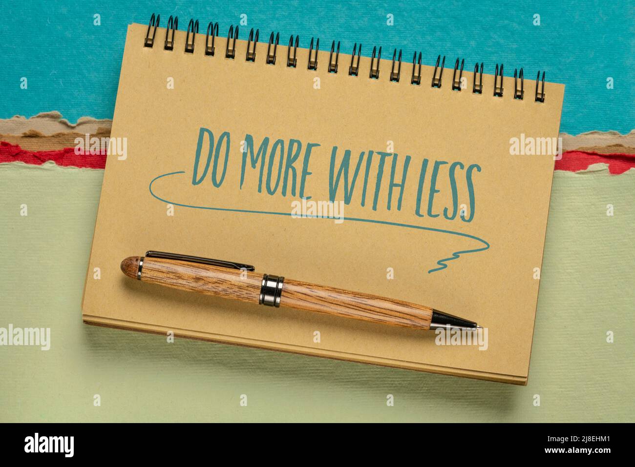 do more with less productivity concept  - handwriting in a spiral notebook against colorful abstract paper landscape, efficiency and personal developm Stock Photo