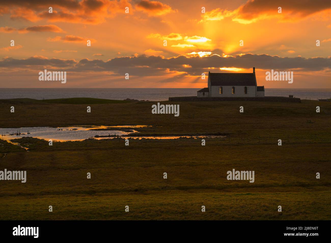 The Kirk on Fair Isle illuminated from behind by a glorious sunset