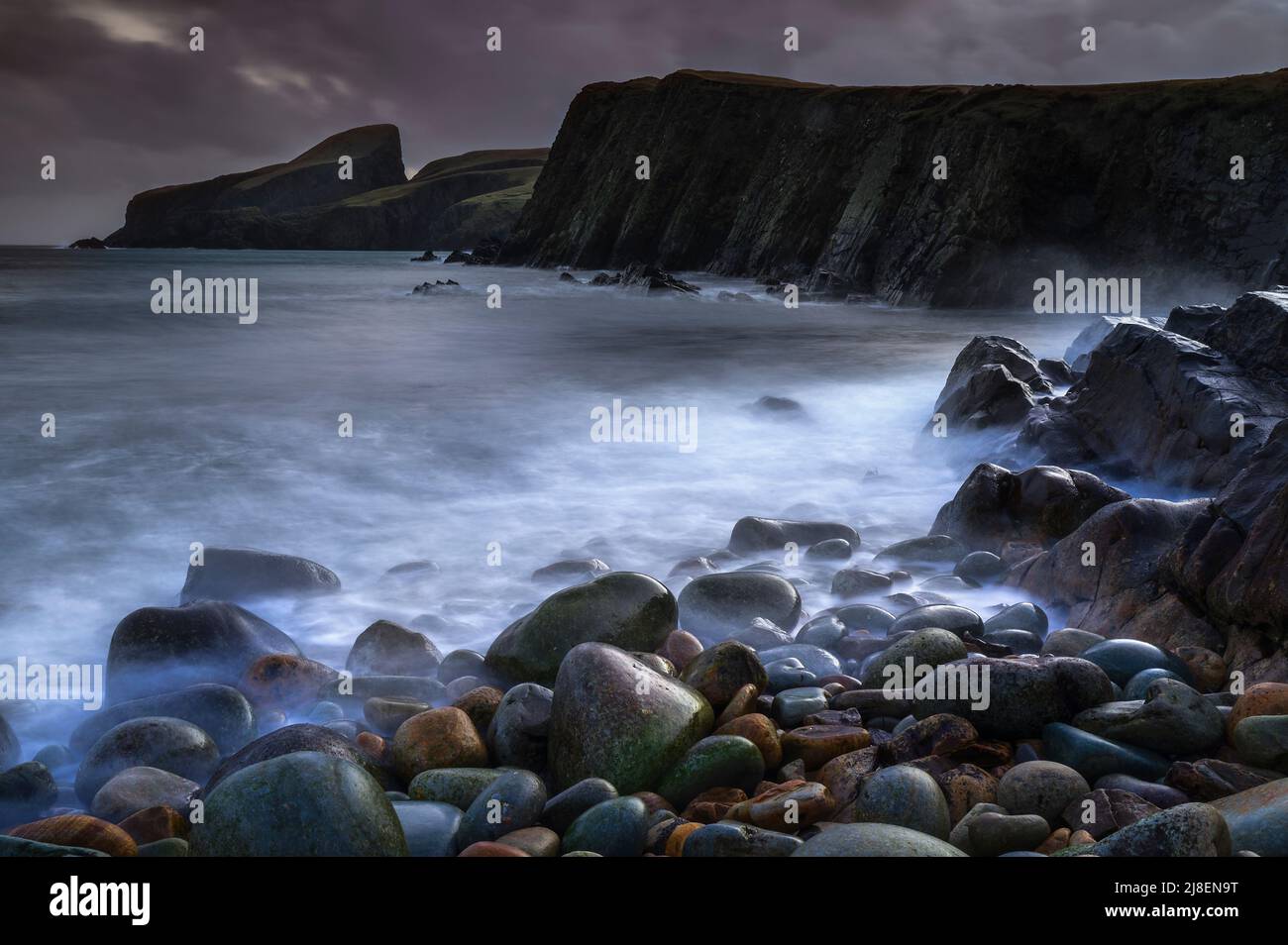 Dark and moody scene with a brooding sky over the stoney beach at North Haven, Fair Isle Stock Photo