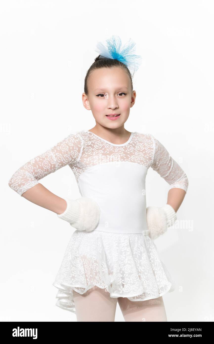 Portrait of caucasian girl ballerina nine-year-old in white ballet tutu skirt, blue bow in hair and white mittens on white background. Waist up Stock Photo