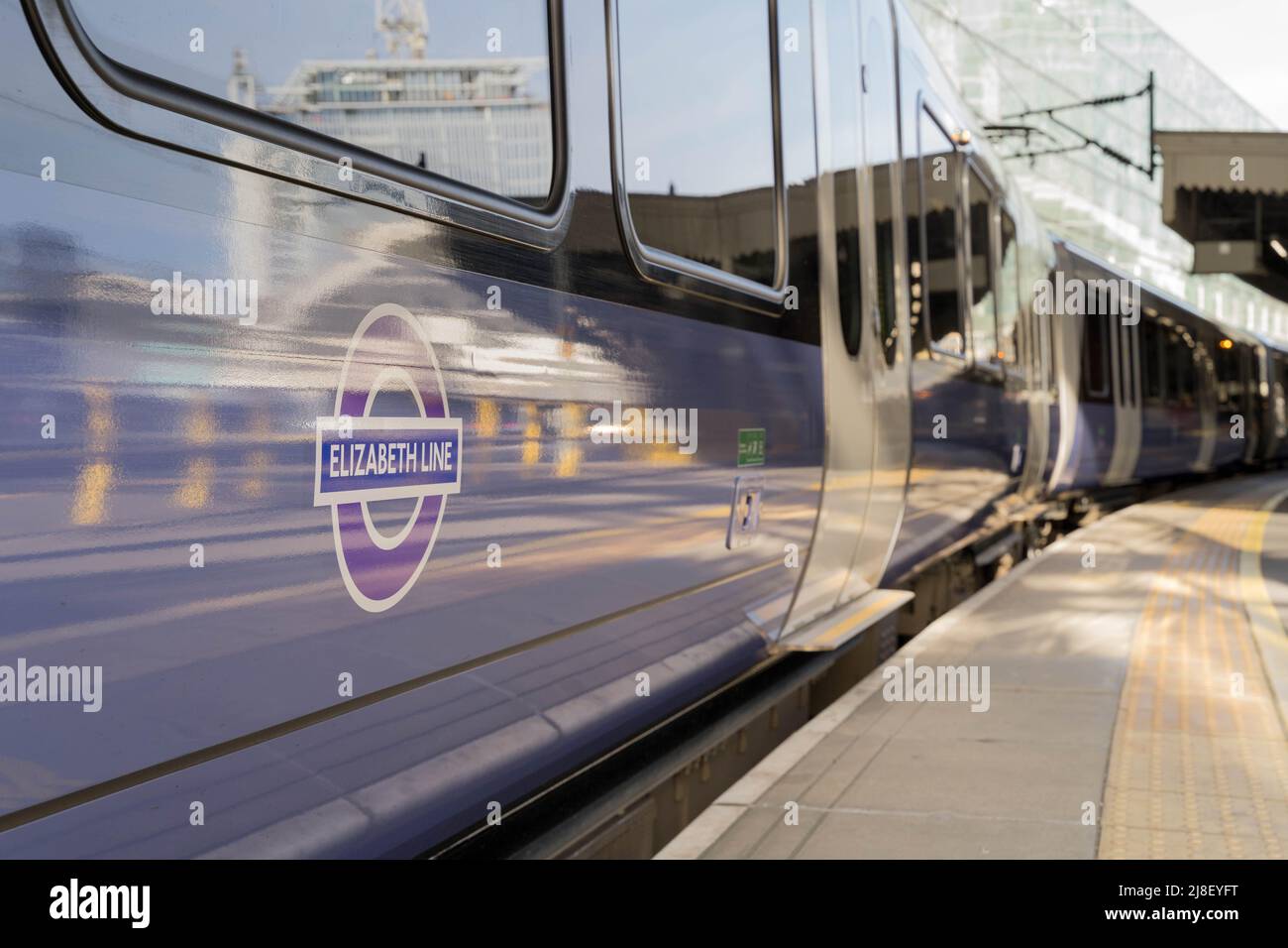 purple Elizabeth Line tube train pulling away from platform London England UK Stock Photo