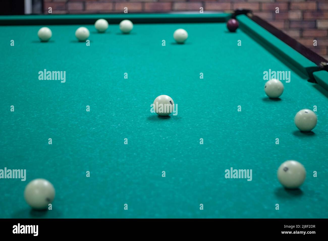 Billiard balls are white. Green billiard table. Playing in bar. Sports